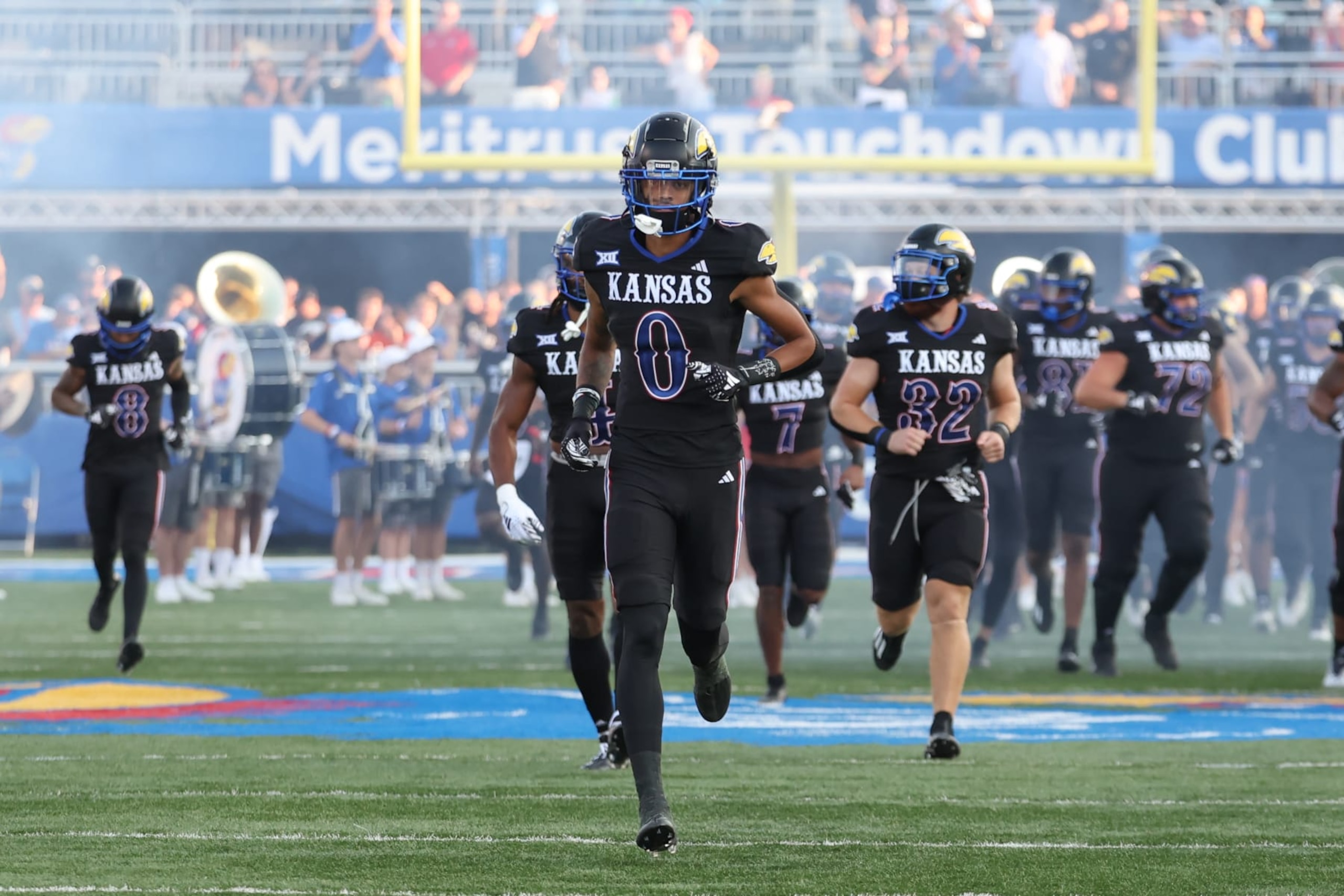 LAWRENCE, KS - SEPTEMBER 08: Kansas Jayhawks players run onto the field before a college football game between the Illinois Fighting Illini and Kansas Jayhawks on Sep 8, 2023 at David Booth memorial Stadium in Lawrence, KS. (Photo by Scott Winters/Icon Sportswire via Getty Images) LAWRENCE, KS - SEPTEMBER 08: Kansas Jayhawks players run onto the field before a college football game between the Illinois Fighting Illini and Kansas Jayhawks on Sep 8, 2023 at David Booth memorial Stadium in Lawrence, KS. (Photo by Scott Winters/Icon Sportswire via Getty Images)