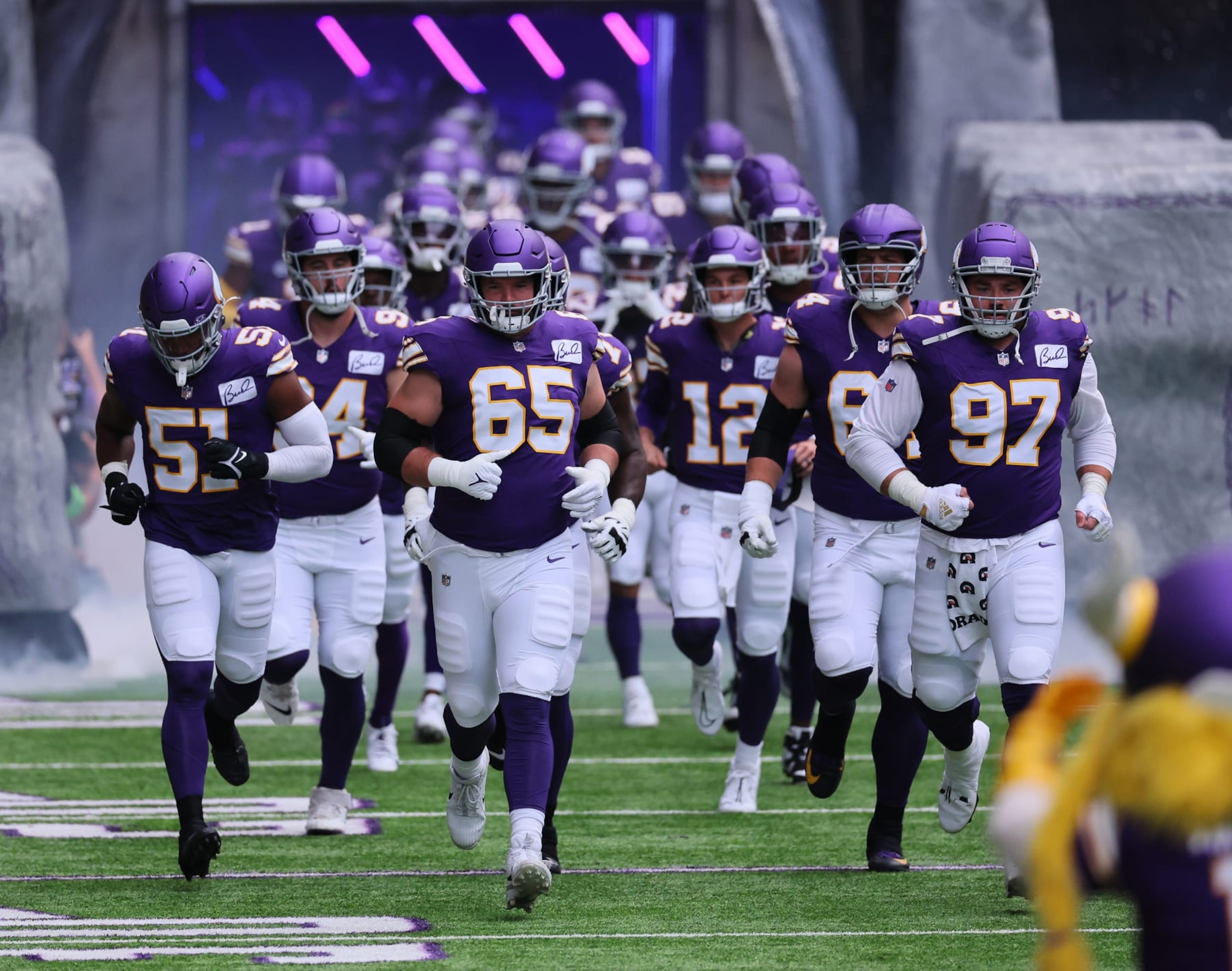 MINNEAPOLIS, MINNESOTA - SEPTEMBER 10: Austin Schlottmann #65 and Harrison Phillips #97 of the Minnesota Vikings lead the way on the field against the Tampa Bay Buccaneers at U.S. Bank Stadium on September 10, 2023 in Minneapolis, Minnesota. The Tampa Bay Buccaneers defeated the Minnesota Vikings 20-17.(Photo by Adam Bettcher/Getty Images)