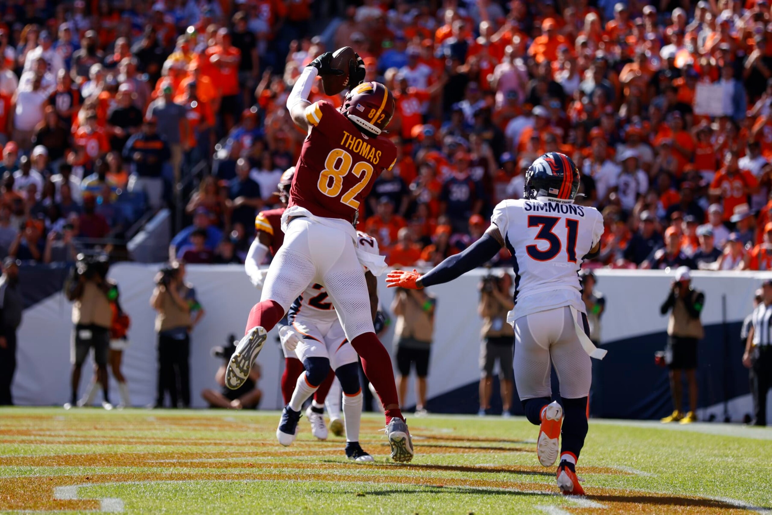 DENVER, COLORADO - SEPTEMBER 17: Logan Thomas #82 of the Washington Commanders catches a touchdown in front of Justin Simmons #31 of the Denver Broncos during the second quarter at Empower Field At Mile High on September 17, 2023 in Denver, Colorado. (Photo by Justin Edmonds/Getty Images)