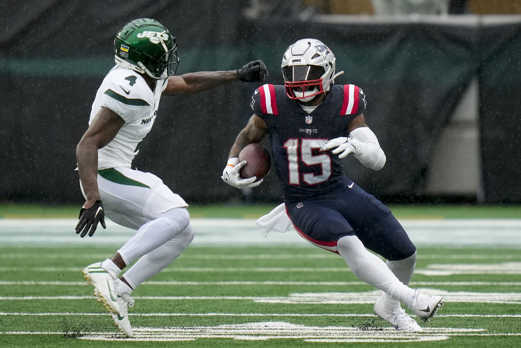 Patriots RB Ezekiel Elliott runs past Jets CB D.J. Reed. 
