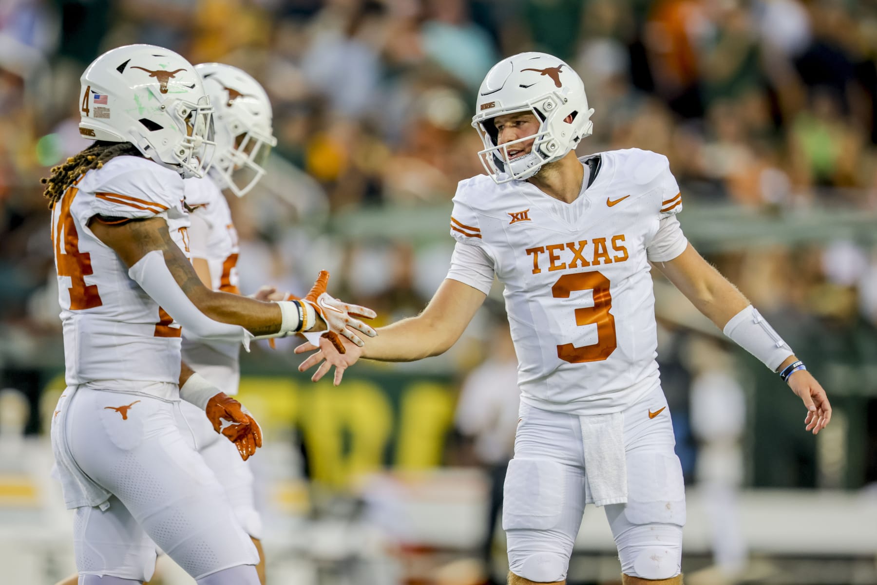 Texas quarterback Quinn Ewers (3) shakes hands with running back Jonathon Brooks during the first half of the team's NCAA college football game against Baylor, Saturday, Sept. 23, 2023, in Waco, Texas. (AP Photo/Gareth Patterson)