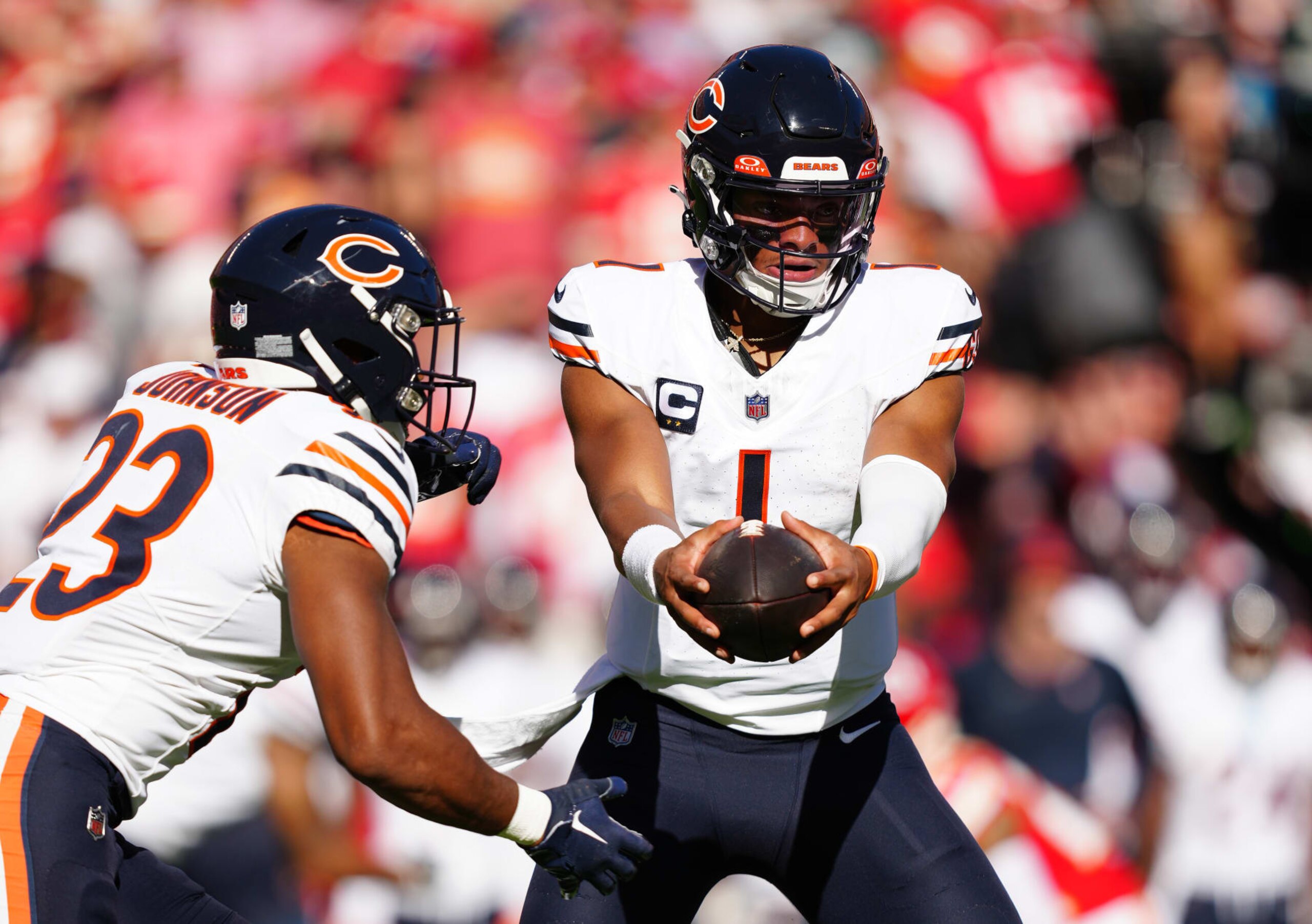KANSAS CITY, MISSOURI - SEPTEMBER 24: Justin Fields #1 of the Chicago Bears hands the ball off to Roschon Johnson #23 of the Chicago Bears during a game against the Kansas City Chiefs at GEHA Field at Arrowhead Stadium on September 24, 2023 in Kansas City, Missouri. (Photo by Jason Hanna/Getty Images)