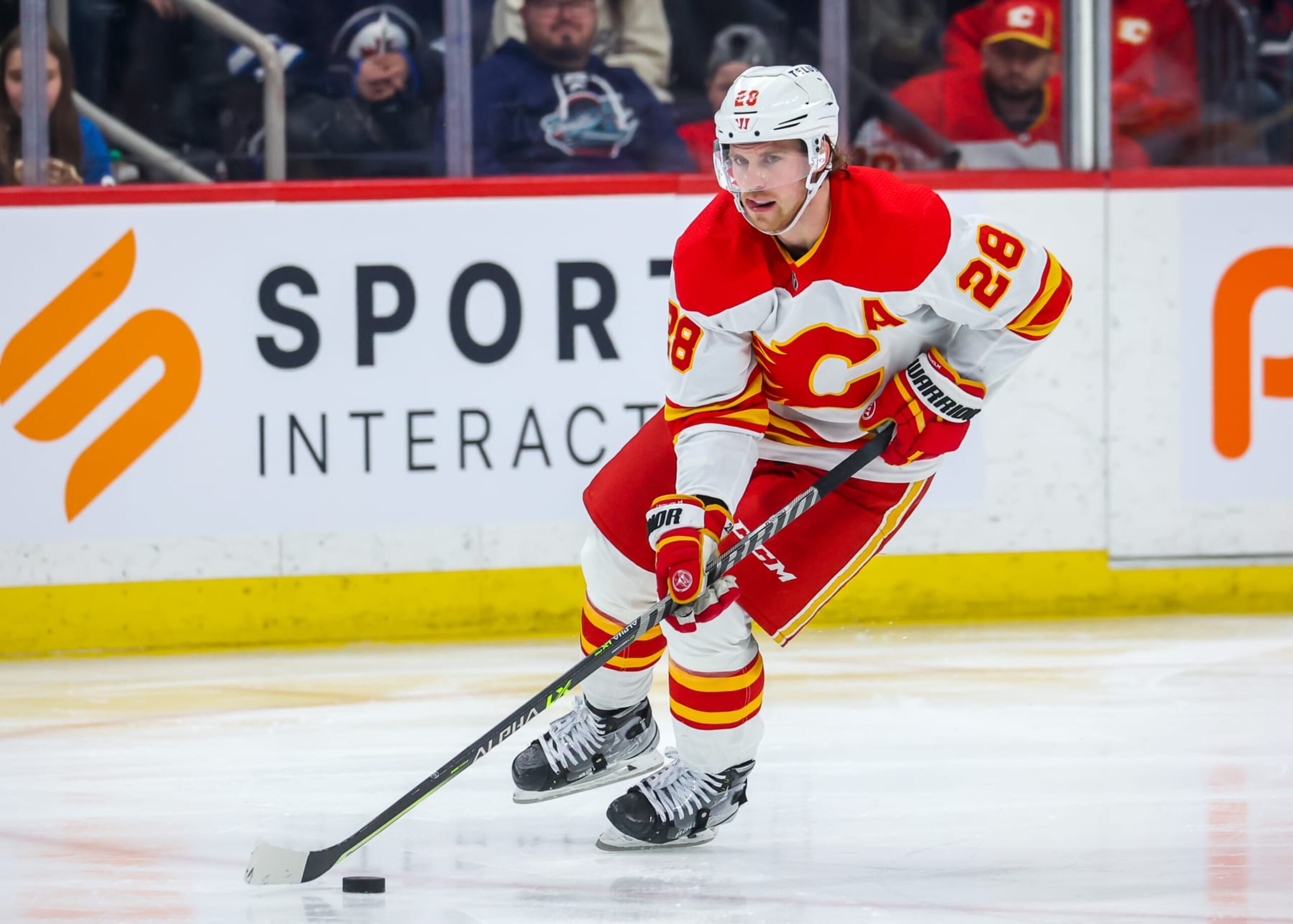 WINNIPEG, CANADA - APRIL 05: Elias Lindholm #28 of the Calgary Flames plays the puck during third period action against the Winnipeg Jets at Canada Life Centre on April 05, 2023 in Winnipeg, Manitoba, Canada. (Photo by Jonathan Kozub/NHLI via Getty Images)