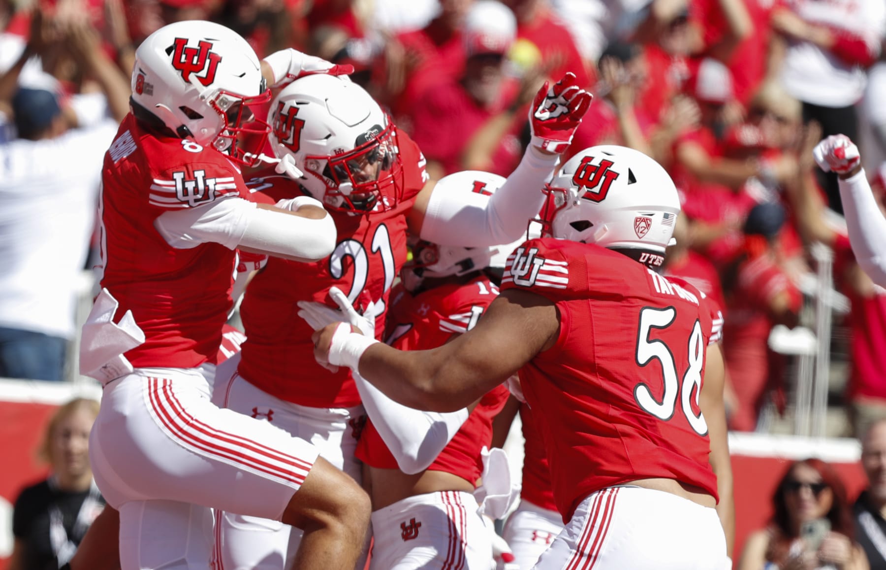 SALT LAKE CITY, UT - SEPTEMBER 23: Karene Reid #21 of the Utah Utes is congratulated by teammates Cole Bishop #8 and Junior Tafuna #58 after running back an interception for touchdown against the UCLA Bruins during the first half of their game at Rice-Eccles Stadium on September 23, 2023 in Salt Lake City, Utah. (Photo by Chris Gardner/Getty Images)