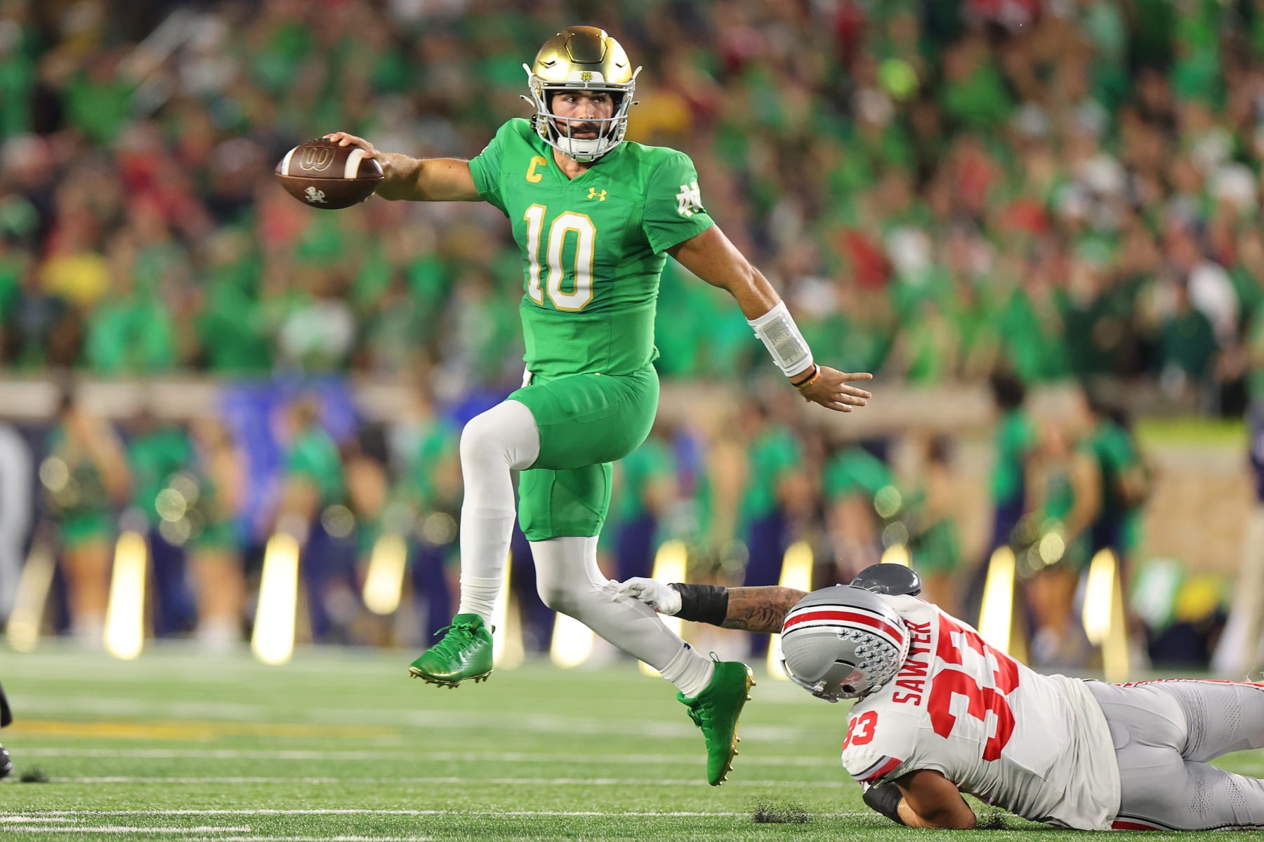 SOUTH BEND, INDIANA - SEPTEMBER 23: Sam Hartman #10 of the Notre Dame Fighting Irish breaks a tackle from Jack Sawyer #33 of the Ohio State Buckeyes during the first half at Notre Dame Stadium on September 23, 2023 in South Bend, Indiana. (Photo by Michael Reaves/Getty Images)