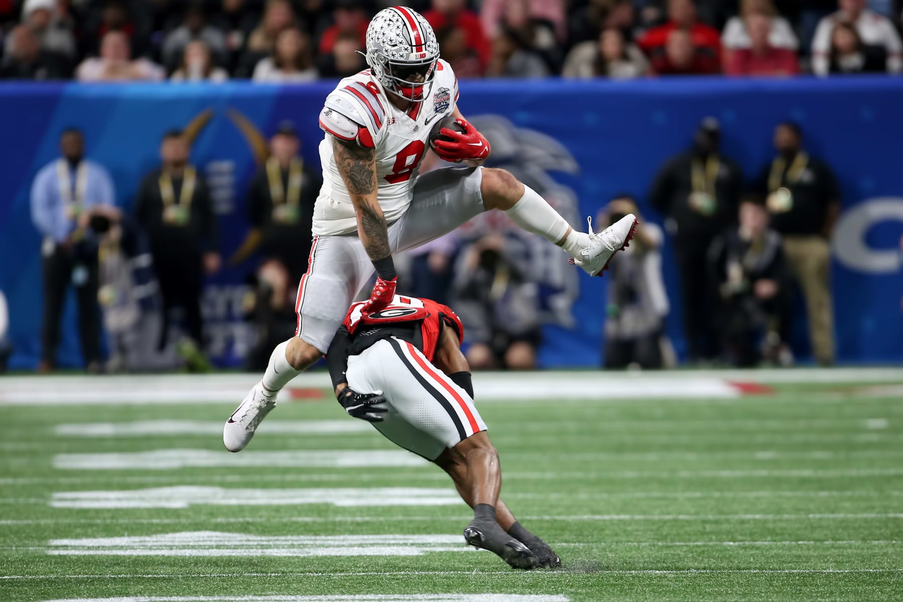 ATLANTA, GA - DECEMBER 31:  Ohio State Buckeyes tight end Cade Stover (8) leaps a defender during the college football Playoff Semifinal game at the Chick-fil-a Peach Bowl between the Georgia Bulldogs and the Ohio State Buckeyes on December 31, 2022 at Mercedes-Benz Stadium in Atlanta, Georgia.  (Photo by Michael Wade/Icon Sportswire via Getty Images)