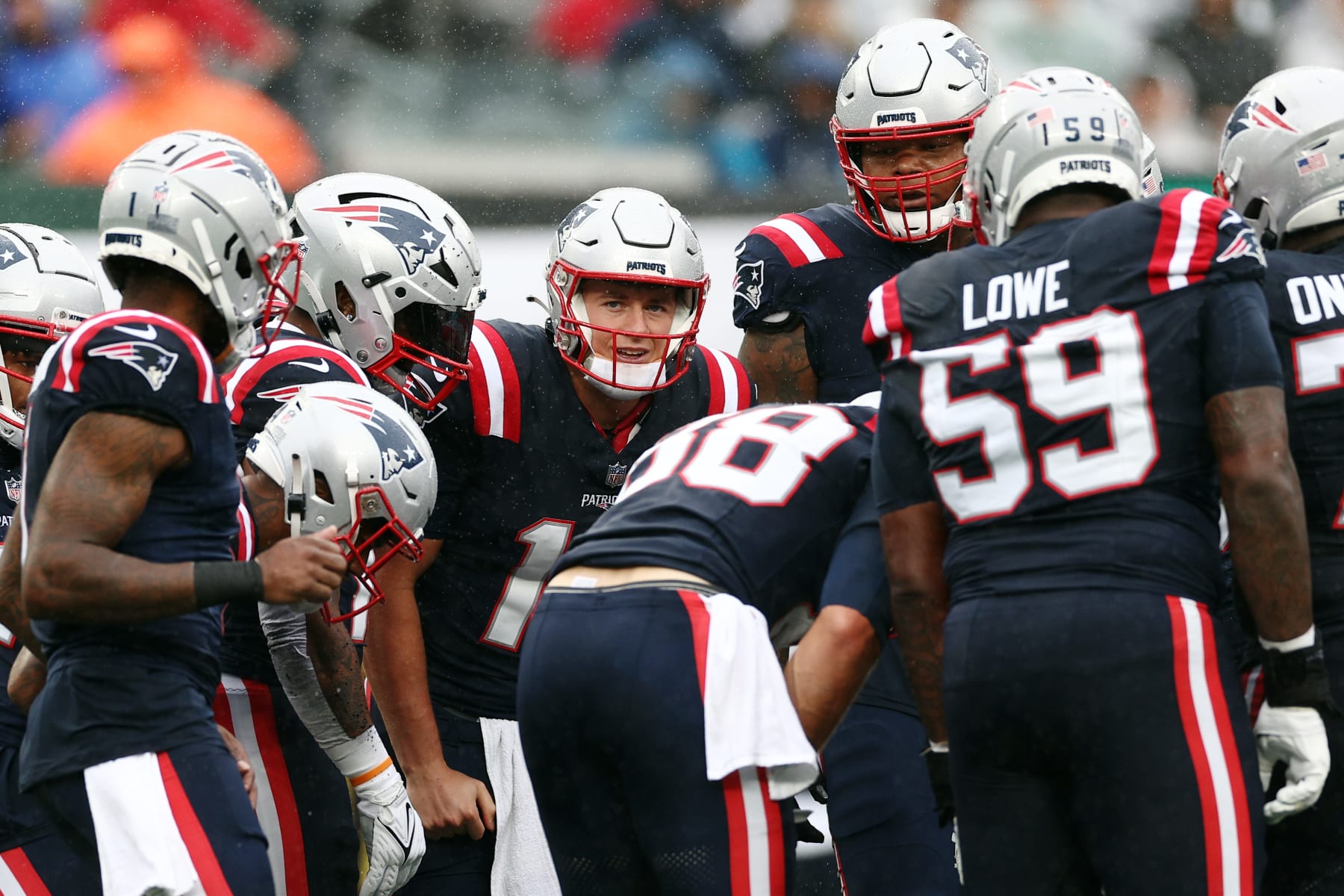 EAST RUTHERFORD, NEW JERSEY - SEPTEMBER 24: Mac Jones #10 of the New England Patriots huddles with the team in the first half of a game against the New York Jets at MetLife Stadium on September 24, 2023 in East Rutherford, New Jersey. (Photo by Elsa/Getty Images)