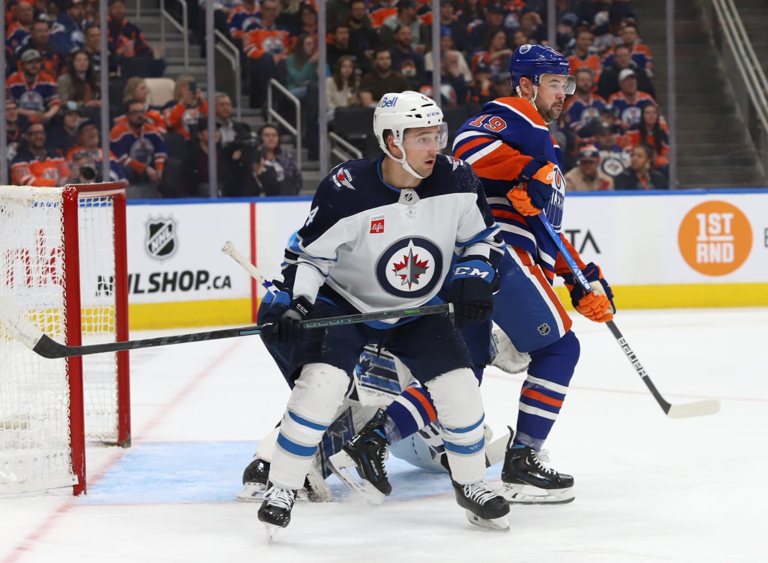 EDMONTON, CANADA - MARCH 3: Devin Shore #19 of the Edmonton Oilers and Neal Pionk #4 of the Winnipeg Jets battle for position during the game on March 3, 2023 at Rogers Place in Edmonton, Alberta, Canada. (Photo by Lawrence Scott/NHLI via Getty Images)