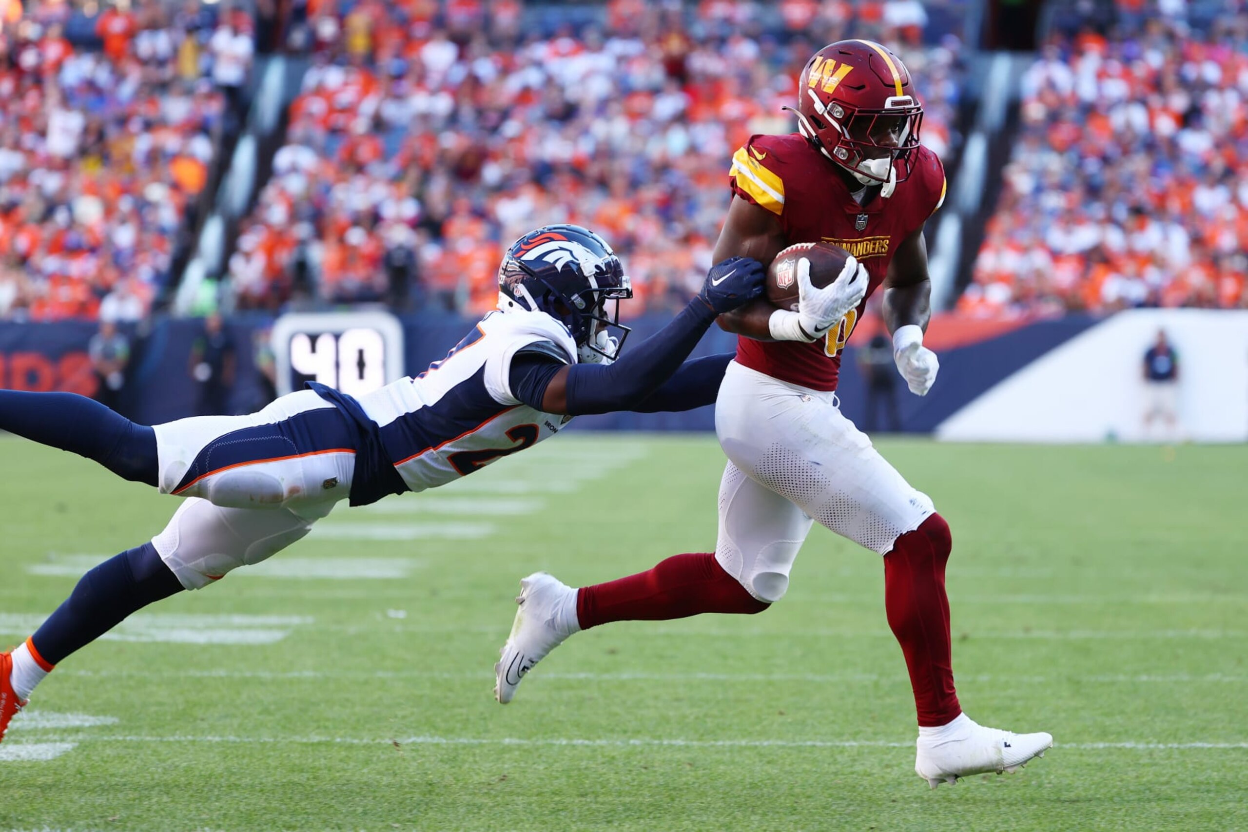 DENVER, COLORADO - SEPTEMBER 17: Brian Robinson Jr. #8 of the Washington Commanders rushes for a touchdown against Damarri Mathis #27 of the Denver Broncos at Empower Field At Mile High on September 17, 2023 in Denver, Colorado. (Photo by Jamie Schwaberow/Getty Images)