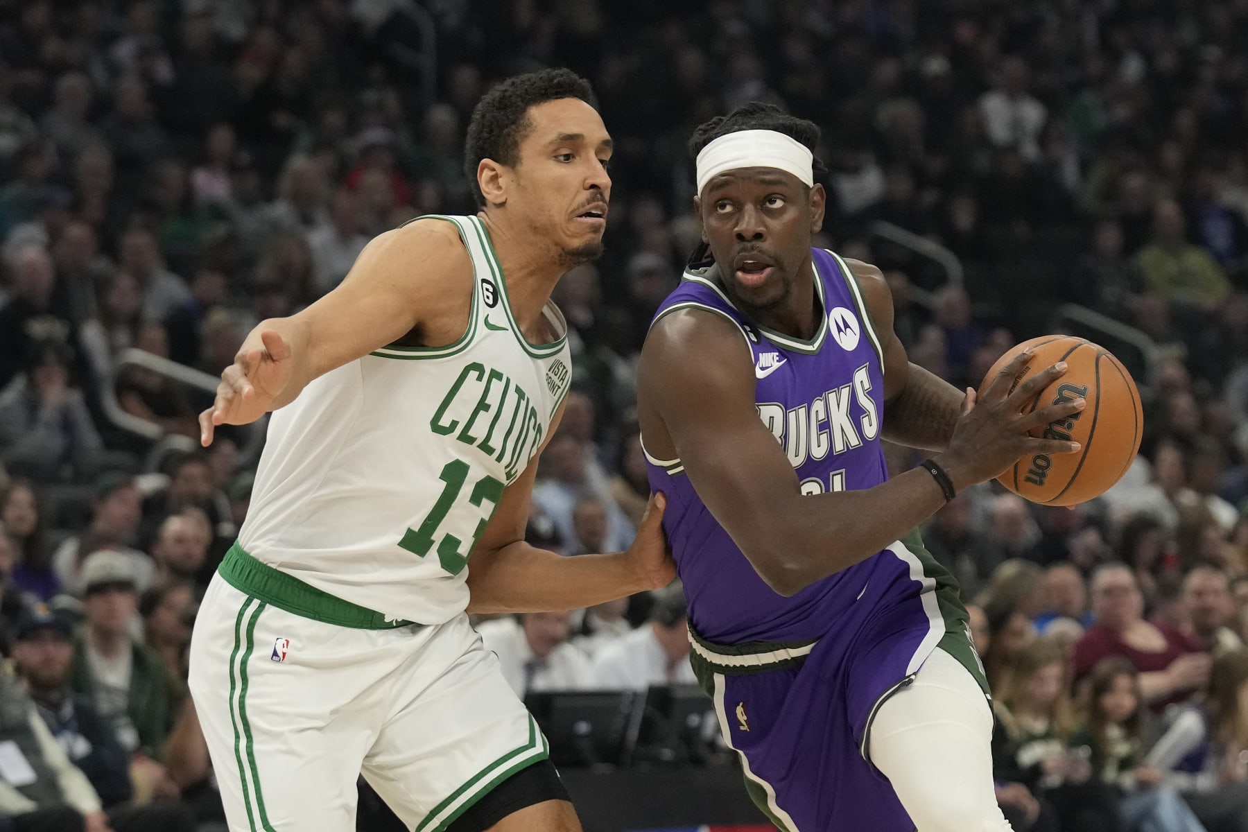 MILWAUKEE, WISCONSIN - MARCH 30: Jrue Holiday #21 of the Milwaukee Bucks dribbles the ball against Malcolm Brogdon #13 of the Boston Celtics in the first half at Fiserv Forum on March 30, 2023 in Milwaukee, Wisconsin. NOTE TO USER: User expressly acknowledges and agrees that, by downloading and or using this photograph, user is consenting to the terms and conditions of the Getty Images License Agreement. (Photo by Patrick McDermott/Getty Images)