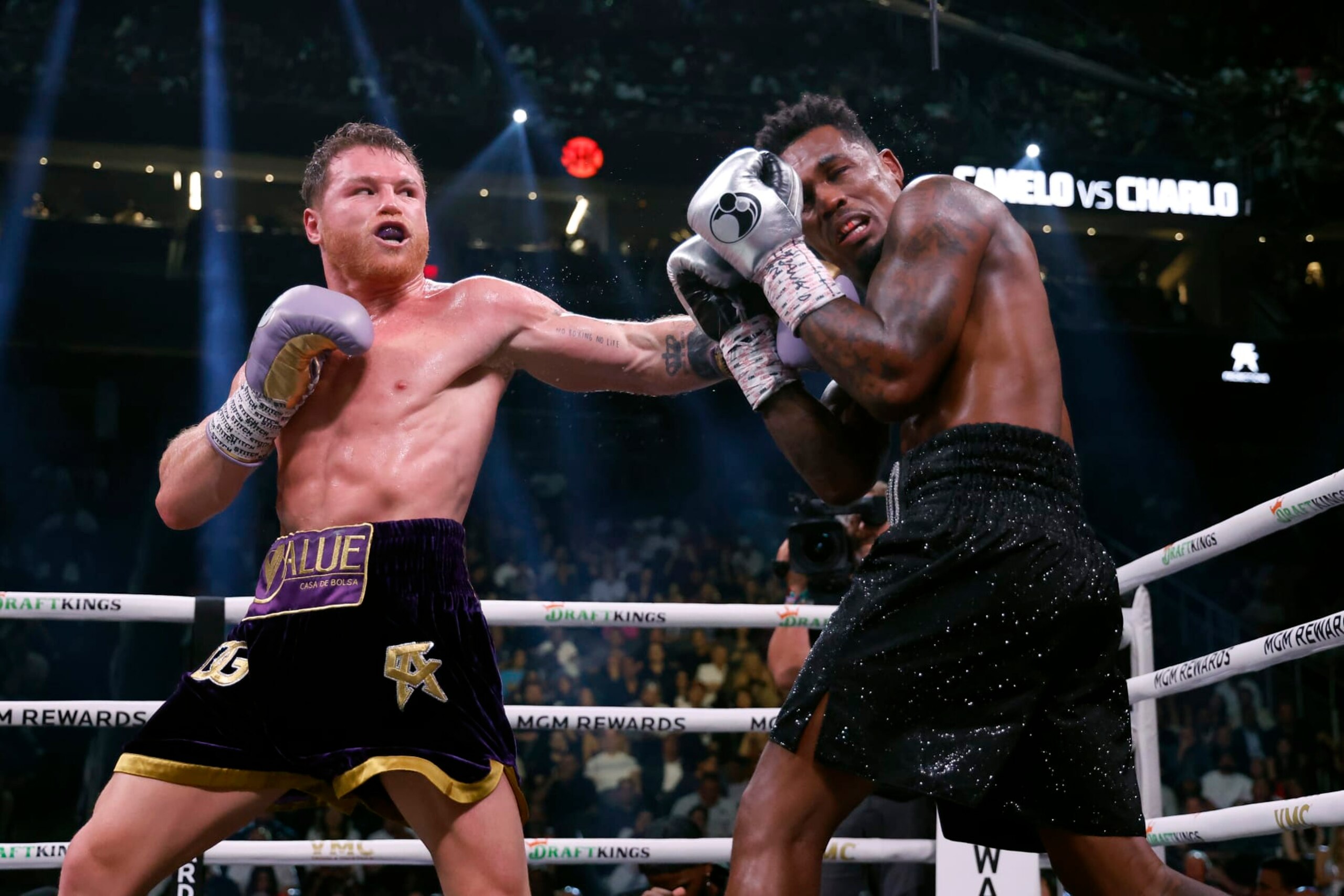 LAS VEGAS, NEVADA - SEPTEMBER 30:   Saul "Canelo" Alvarez of Mexico (purple/gold trunks) trades punches with Jermell Charlo (black trunks) during their super middleweight title fight at T-Mobile Arena on September 30, 2023 in Las Vegas, Nevada.  (Photo by Sarah Stier/Getty Images)