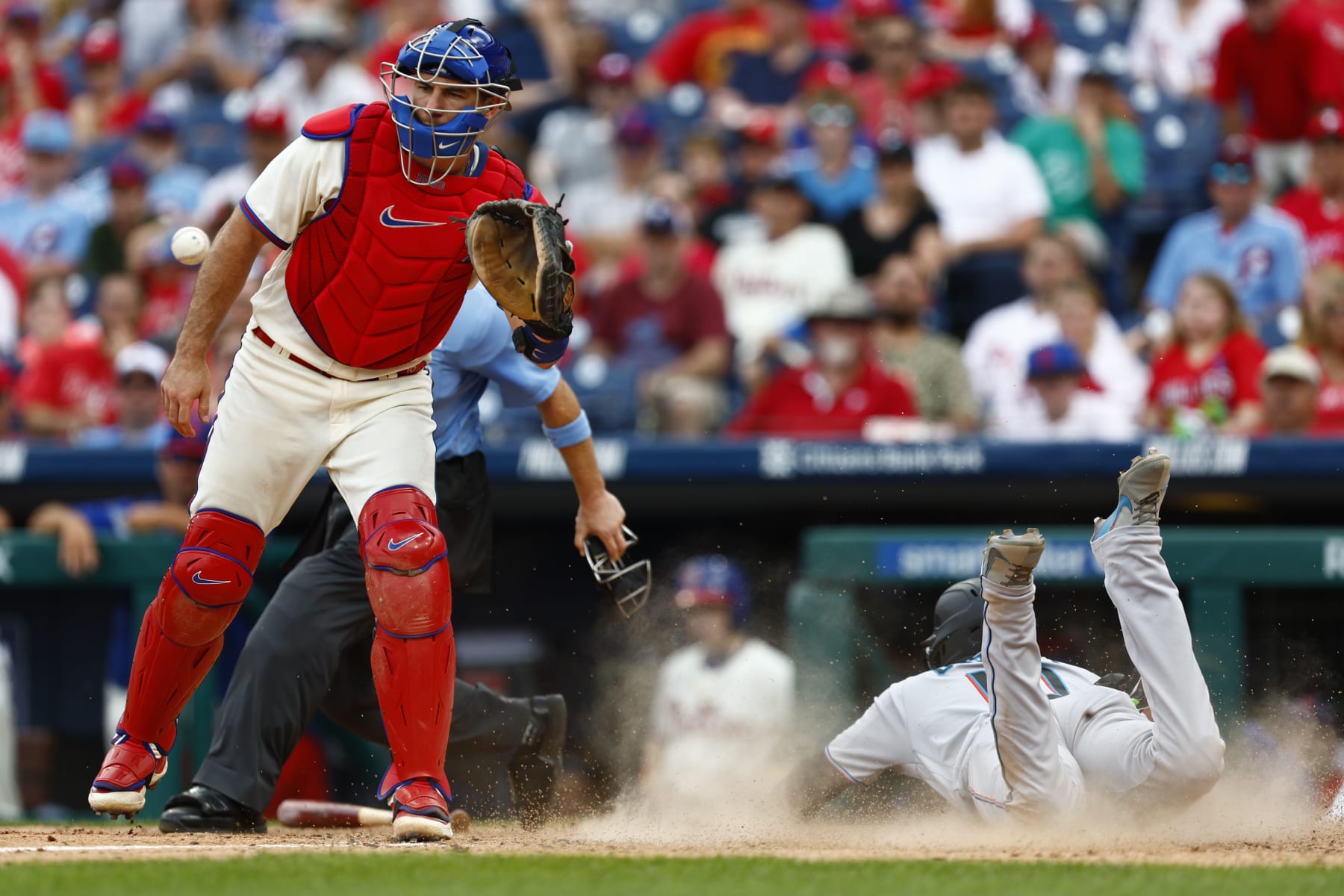 PHILADELPHIA, PENNSYLVANIA - SEPTEMBER 10: Yuli Gurriel #10 of the Miami Marlins slides in to score on a single by Nick Fortes (not in the picture) #4 as catcher J.T. Realmuto (L) #10 of the Philadelphia Phillies waits for the ball in the seventh inning at Citizens Bank Park on September 10, 2023 in Philadelphia, Pennsylvania. The Marlins defeated the Phillies 5-4. (Photo by Rich Schultz/Getty Images)