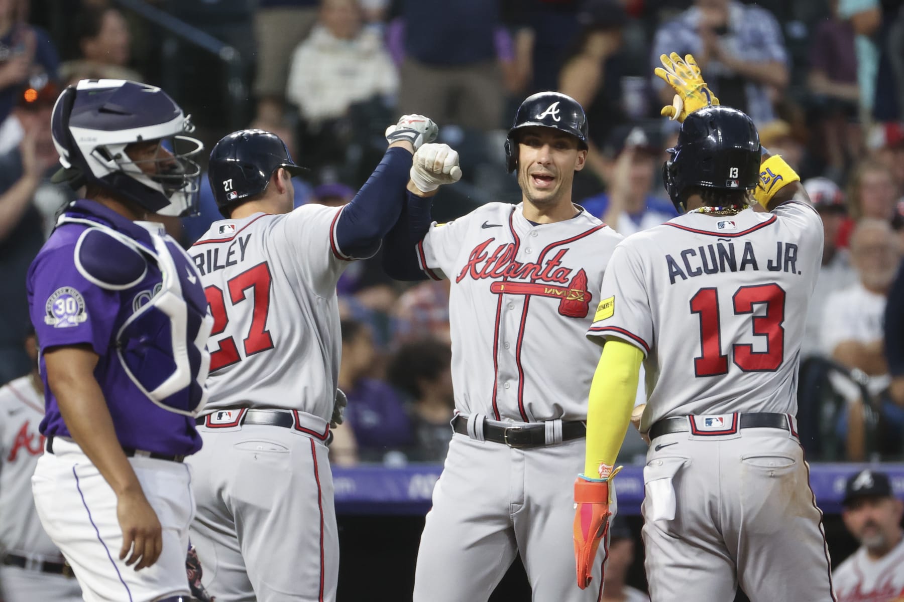 DENVER, COLORADO - AUGUST 28: (L-R) Austin Riley #27, Matt Olson #28, and Ronald Acuna Jr. #13 of the Atlanta Braves celebrate Riley's home run against the Colorado Rockies at Coors Field on August 28, 2023 in Denver, Colorado. (Photo by Tyler Schank/Clarkson Creative/Getty Images)