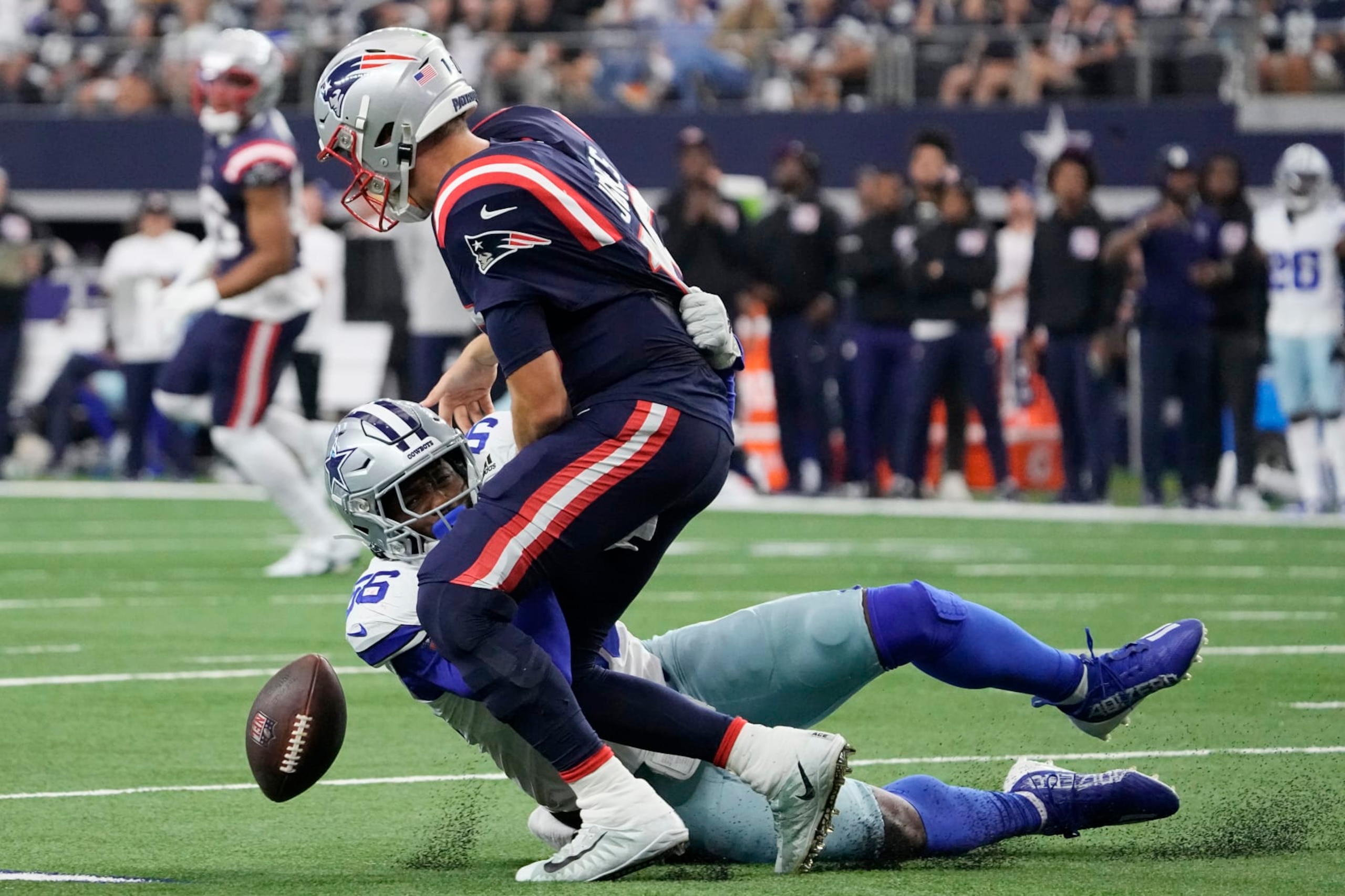 ARLINGTON, TEXAS - OCTOBER 01: Mac Jones #10 of the New England Patriots fumbles the ball while being tackled by Dante Fowler Jr. #56 of the Dallas Cowboys during the second quarter at AT&T Stadium on October 01, 2023 in Arlington, Texas. (Photo by Sam Hodde/Getty Images) ARLINGTON, TEXAS - OCTOBER 01: Mac Jones #10 of the New England Patriots fumbles the ball while being tackled by Dante Fowler Jr. #56 of the Dallas Cowboys during the second quarter at AT&T Stadium on October 01, 2023 in Arlington, Texas. (Photo by Sam Hodde/Getty Images)