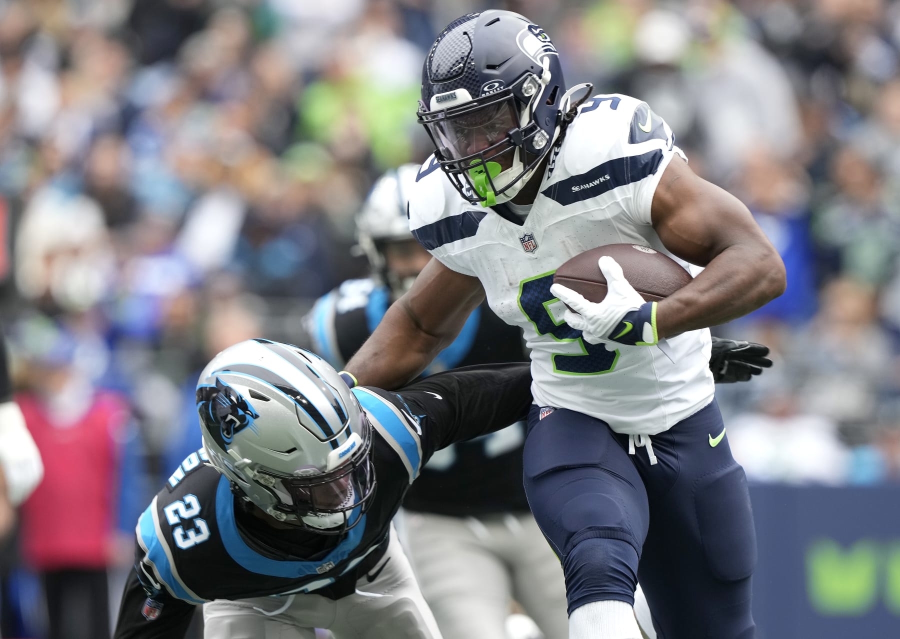 SEATTLE, WASHINGTON - SEPTEMBER 24: Kenneth Walker III #9 of the Seattle Seahawks stiff arms CJ Henderson #23 of the Carolina Panthers during the first quarter at Lumen Field on September 24, 2023 in Seattle, Washington. (Photo by Christopher Mast/Getty Images)