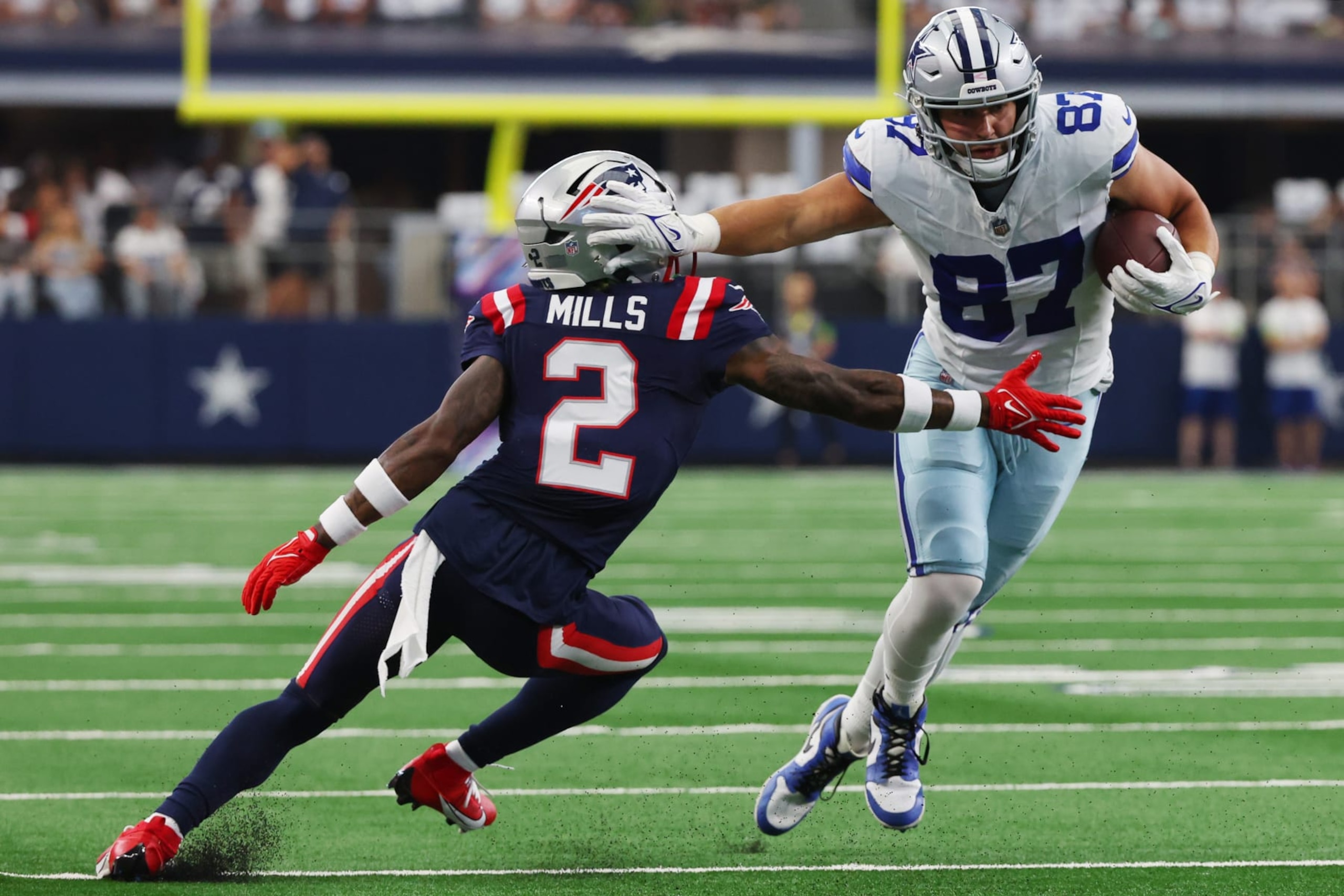 ARLINGTON, TEXAS - OCTOBER 01: Jake Ferguson #87 of the Dallas Cowboys stiff arms Jalen Mills #2 of the New England Patriots during the first half at AT&T Stadium on October 01, 2023 in Arlington, Texas. (Photo by Richard Rodriguez/Getty Images) ARLINGTON, TEXAS - OCTOBER 01: Jake Ferguson #87 of the Dallas Cowboys stiff arms Jalen Mills #2 of the New England Patriots during the first half at AT&T Stadium on October 01, 2023 in Arlington, Texas. (Photo by Richard Rodriguez/Getty Images)