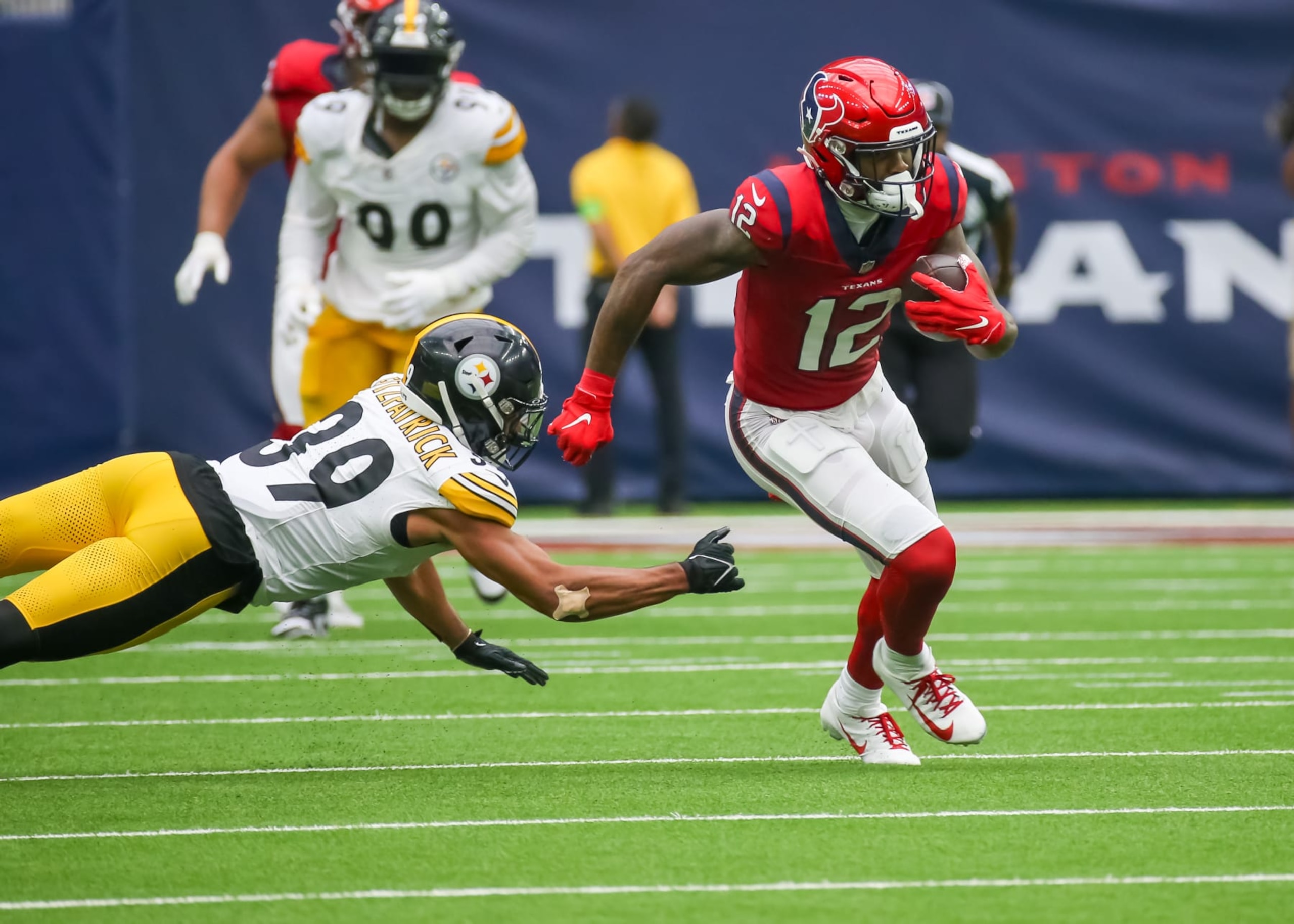 HOUSTON, TX - OCTOBER 01:  Houston Texans wide receiver Nico Collins (12) evades a tackle by Pittsburgh Steelers safety Minkah Fitzpatrick (39) in the second quarter during the NFL game between the Pittsburgh Steelers and Houston Texans on October 1, 2023 at NRG Stadium in Houston, Texas.  (Photo by Leslie Plaza Johnson/Icon Sportswire via Getty Images)
