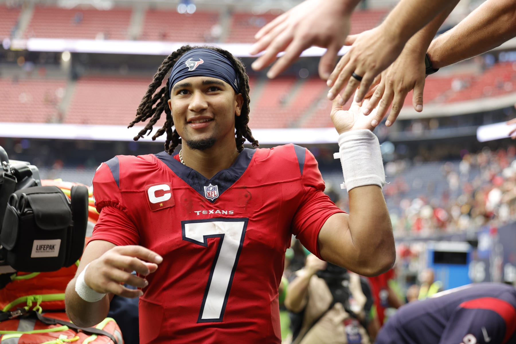 HOUSTON, TEXAS - OCTOBER 01: C.J. Stroud #7 of the Houston Texans high fives fans after his team's 30-6 win against the Pittsburgh Steelers at NRG Stadium on October 01, 2023 in Houston, Texas. (Photo by Carmen Mandato/Getty Images)