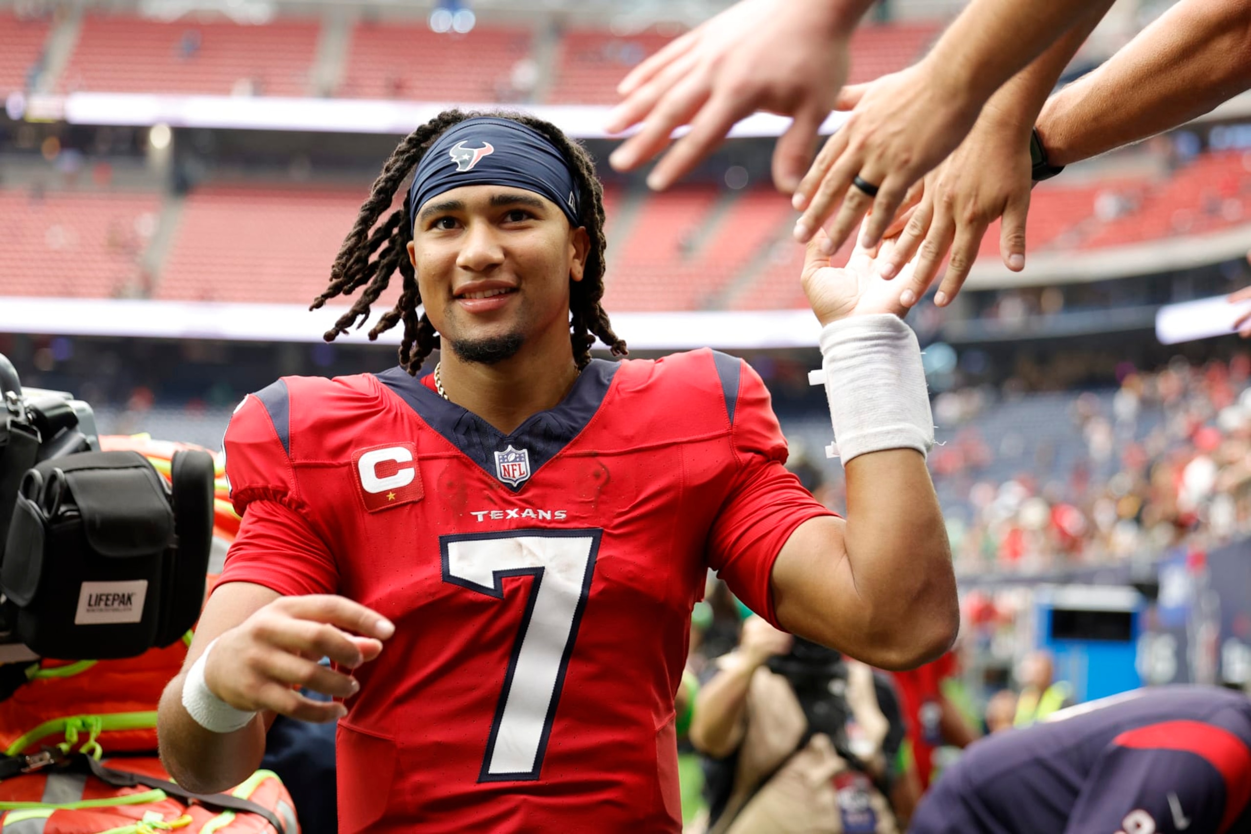 HOUSTON, TEXAS - OCTOBER 01: C.J. Stroud #7 of the Houston Texans high fives fans after his team's 30-6 win against the Pittsburgh Steelers at NRG Stadium on October 01, 2023 in Houston, Texas. (Photo by Carmen Mandato/Getty Images)