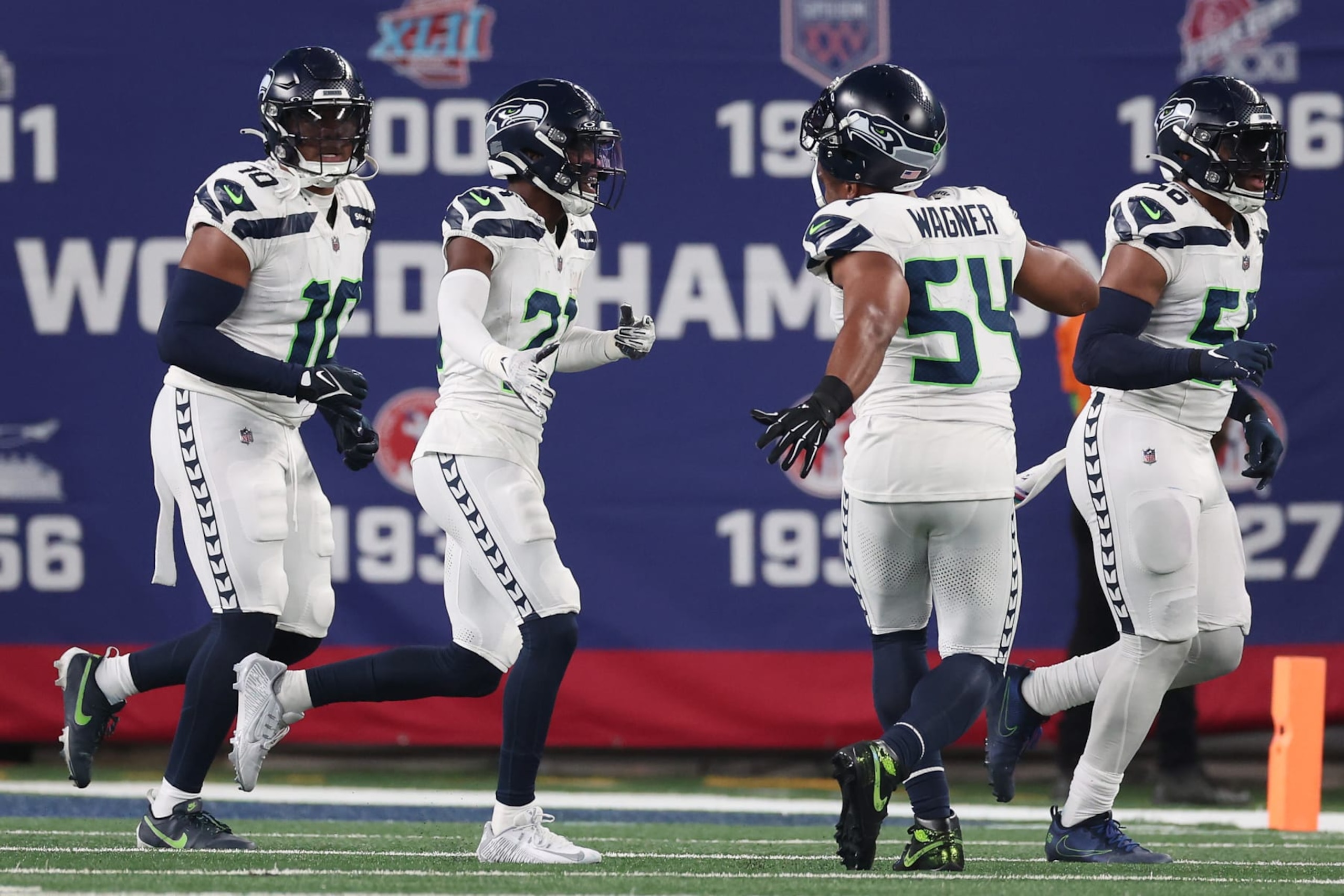 EAST RUTHERFORD, NEW JERSEY - OCTOBER 02: Devon Witherspoon #21 of the Seattle Seahawks celebrates his interception return for a touchdown with teammates during the third quarter against the New York Giants at MetLife Stadium on October 02, 2023 in East Rutherford, New Jersey. (Photo by Al Bello/Getty Images)