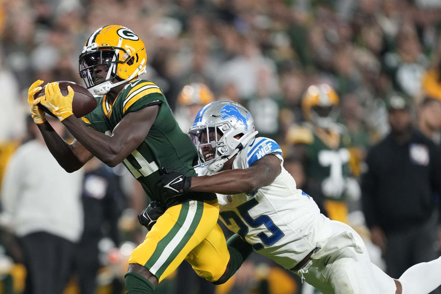GREEN BAY, WISCONSIN - SEPTEMBER 28: Jayden Reed #11 of the Green Bay Packers makes a catch against Will Harris #25 of the Detroit Lions during the third quarter in the game at Lambeau Field on September 28, 2023 in Green Bay, Wisconsin. (Photo by Patrick McDermott/Getty Images)