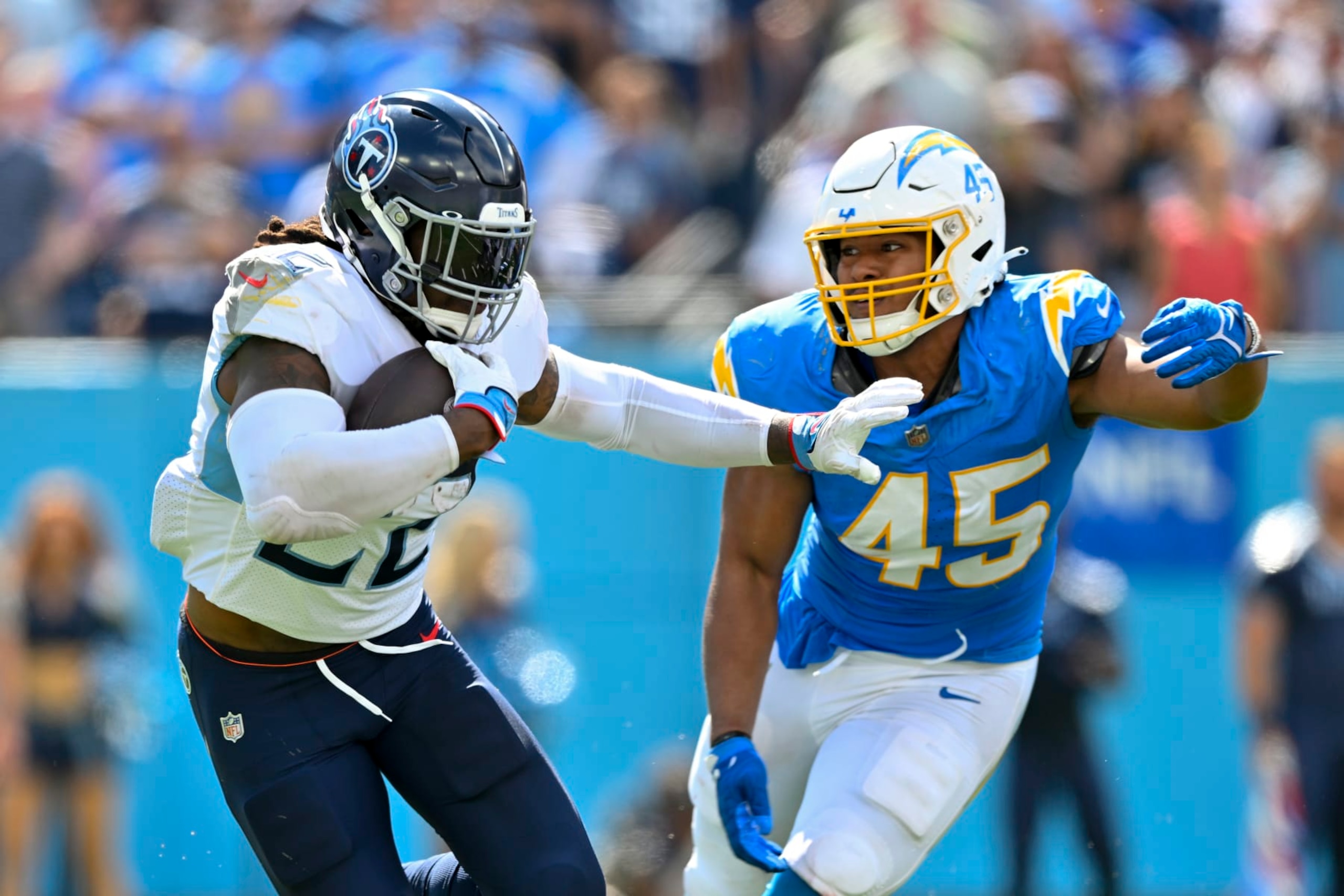 NASHVILLE, TENNESSEE - SEPTEMBER 17: Derrick Henry #22 of the Tennessee Titans runs the ball against Tuli Tuipulotu #45 of the Los Angeles Chargers during an NFL football game at Nissan Stadium on September 17, 2023 in Nashville, Tennessee. The Tennessee Titans won 27-24 in overtime. (Photo by Alika Jenner/Getty Images)