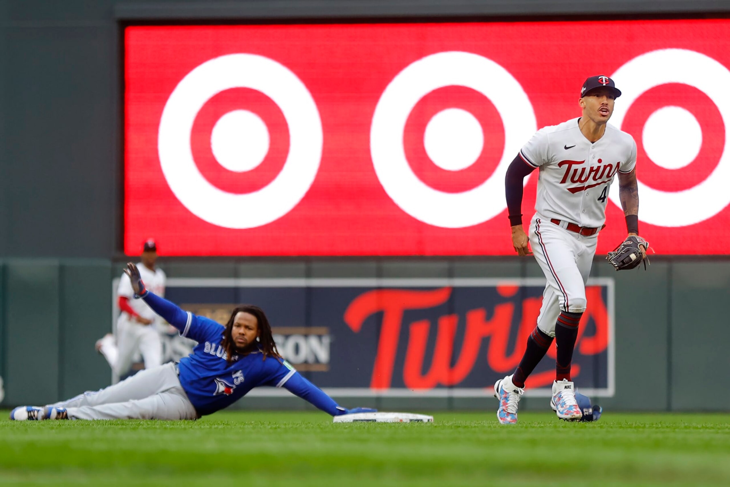 Minnesota Twins shortstop Carlos Correa, right, reacts after tagging out Toronto Blue Jays' Vladimir Guerrero Jr., left, who was picked off second base during the fifth inning of Game 2 of an AL wild-card baseball playoff series Wednesday, Oct. 4, 2023, in Minneapolis. (AP Photo/Bruce Kluckhohn)