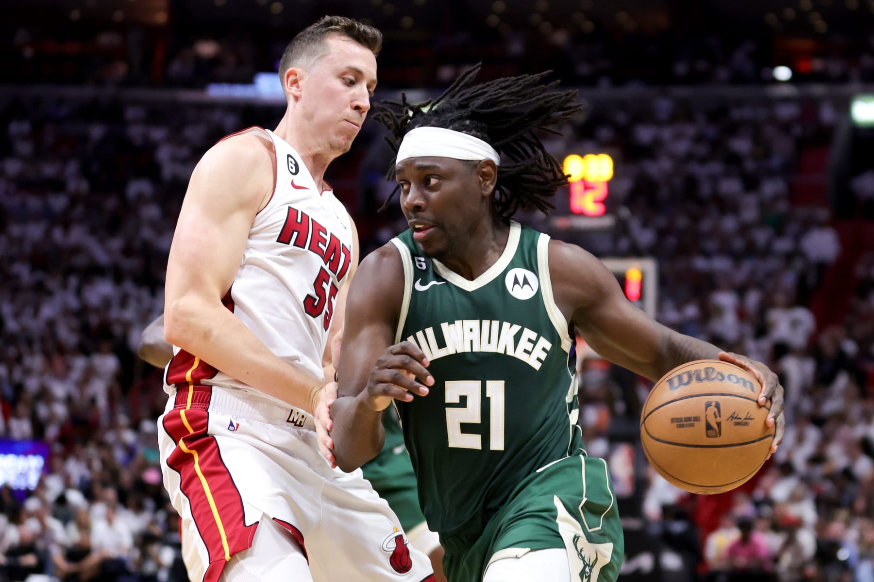MIAMI, FLORIDA - APRIL 22: Jrue Holiday #21 of the Milwaukee Bucks dribbles the ball against Duncan Robinson #55 of the Miami Heat during the fourth quarter in Game Three of the Eastern Conference First Round Playoffs at Kaseya Center on April 22, 2023 in Miami, Florida. NOTE TO USER: User expressly acknowledges and agrees that, by downloading and or using this photograph, User is consenting to the terms and conditions of the Getty Images License Agreement. (Photo by Megan Briggs/Getty Images)