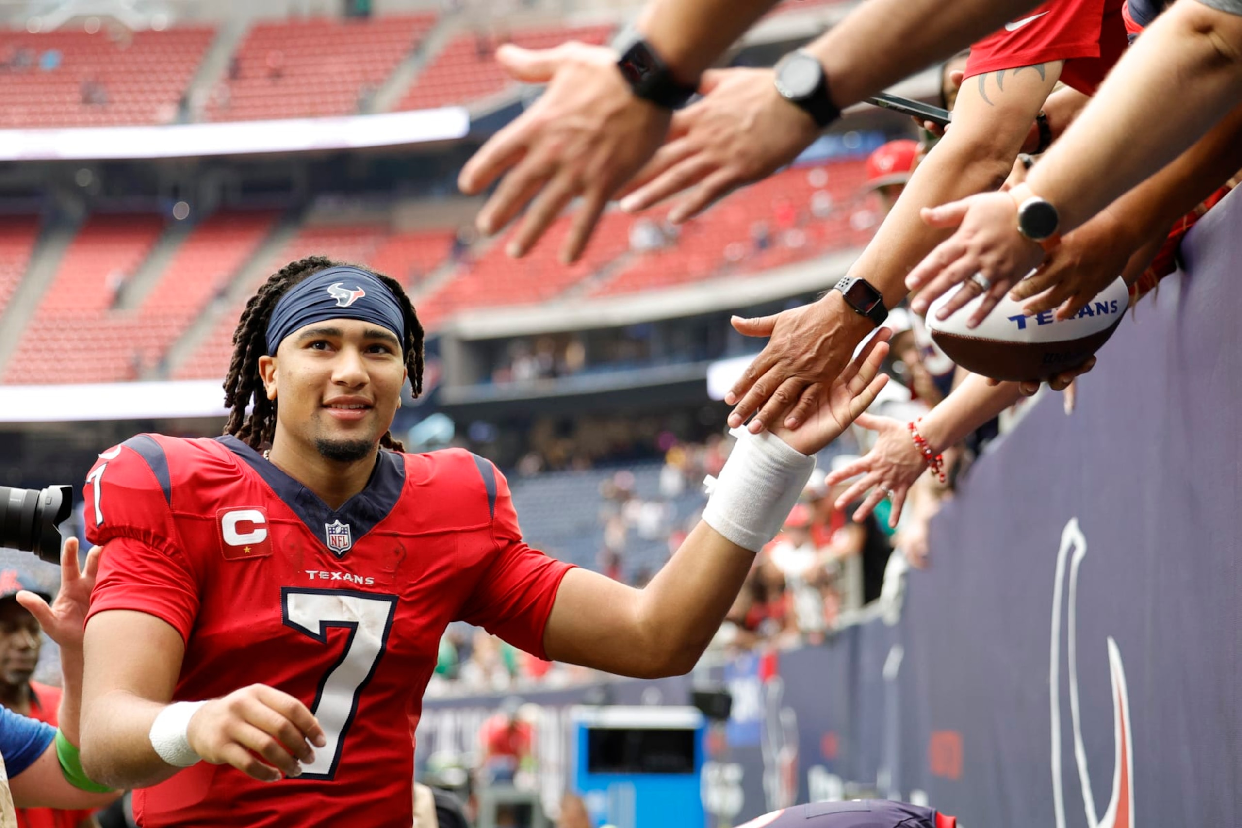 HOUSTON, TEXAS - OCTOBER 01: C.J. Stroud #7 of the Houston Texans high fives fans after his team's 30-6 win against the Pittsburgh Steelers at NRG Stadium on October 01, 2023 in Houston, Texas. (Photo by Carmen Mandato/Getty Images)