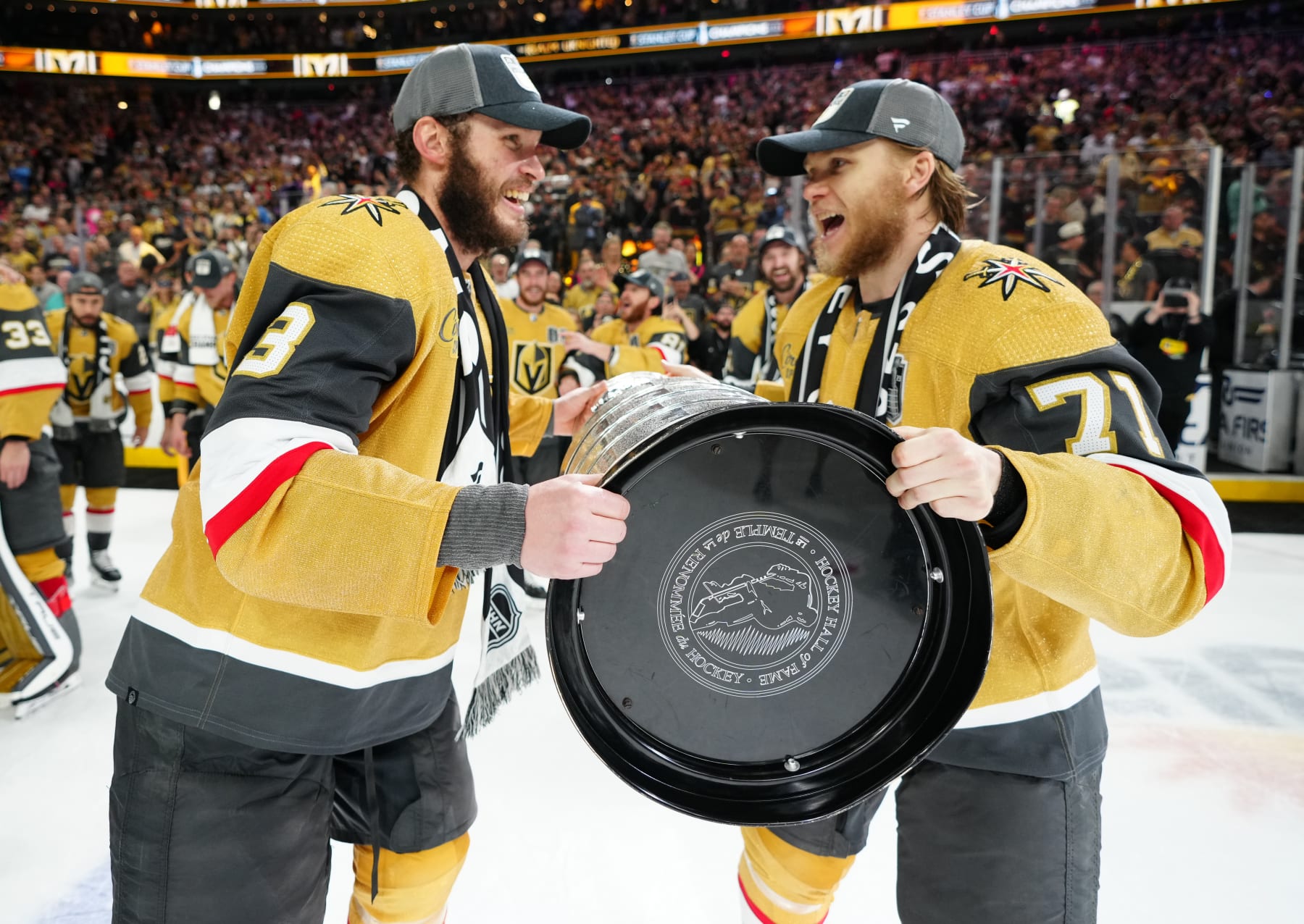 LAS VEGAS, NEVADA - JUNE 13: William Karlsson #71 of the Vegas Golden Knights hands off the Stanley Cup to Brayden McNabb #3 of the Vegas Golden Knights for a celebration lap after a 9-3 victory against the Florida Panthers in Game Five of the 2023 NHL Stanley Cup Final at T-Mobile Arena on June 13, 2023 in Las Vegas, Nevada. (Photo by Jeff Bottari/NHLI via Getty Images)