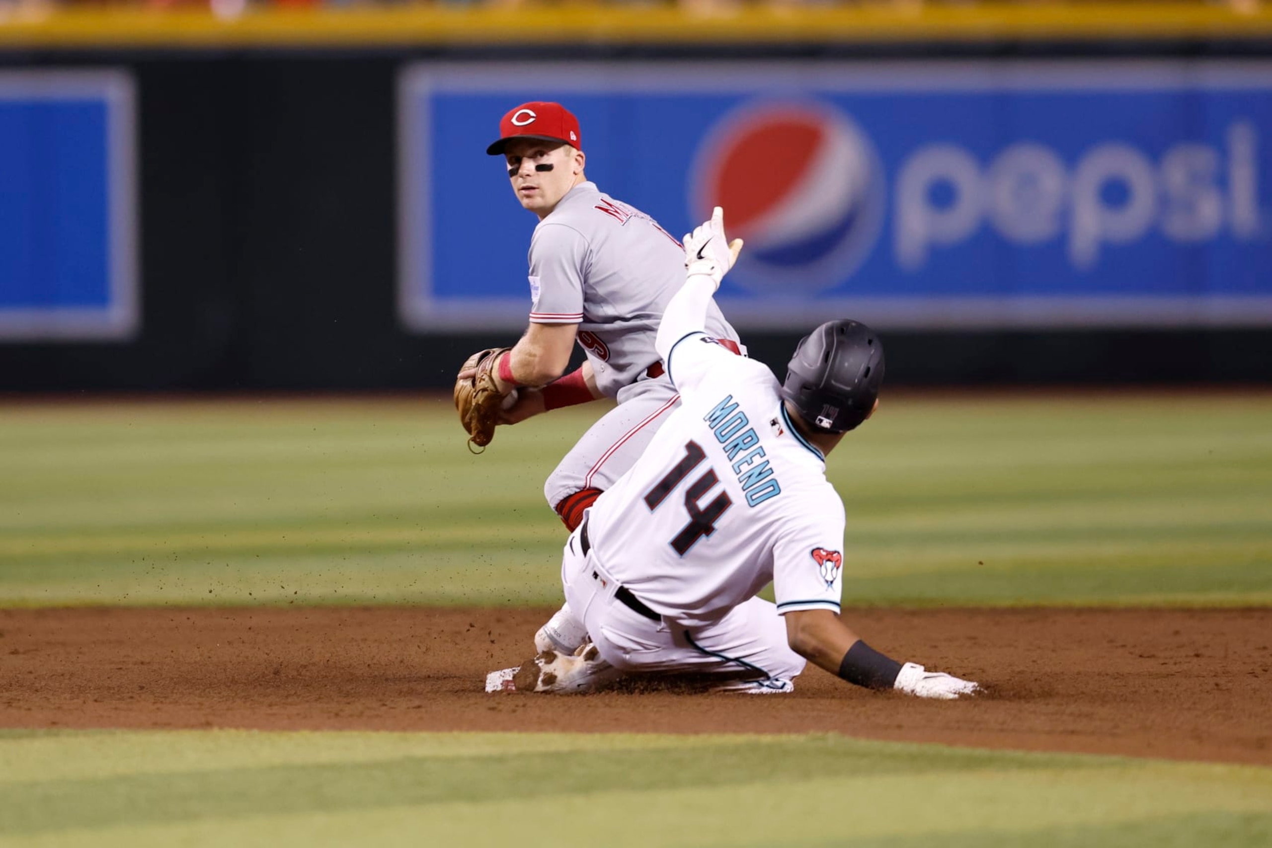 PHOENIX, ARIZONA - AUGUST 24: Gabriel Moreno #14 of the Arizona Diamondbacks safely slides into second base under Matt McLain #9 of the Cincinnati Reds during the third inning at Chase Field on August 24, 2023 in Phoenix, Arizona. The Diamondbacks defeated the Reds 3-2. (Photo by Chris Coduto/Getty Images)