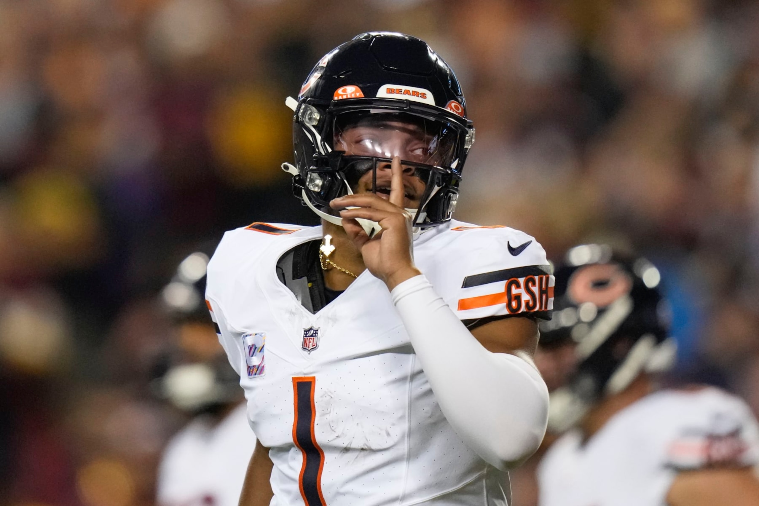Chicago Bears quarterback Justin Fields (1) gestures after throwing a touchdown pass to wide receiver DJ Moore during the first half of an NFL football game against the Washington Commanders, Thursday, Oct. 5, 2023, in Landover, Md. (AP Photo/Alex Brandon)
