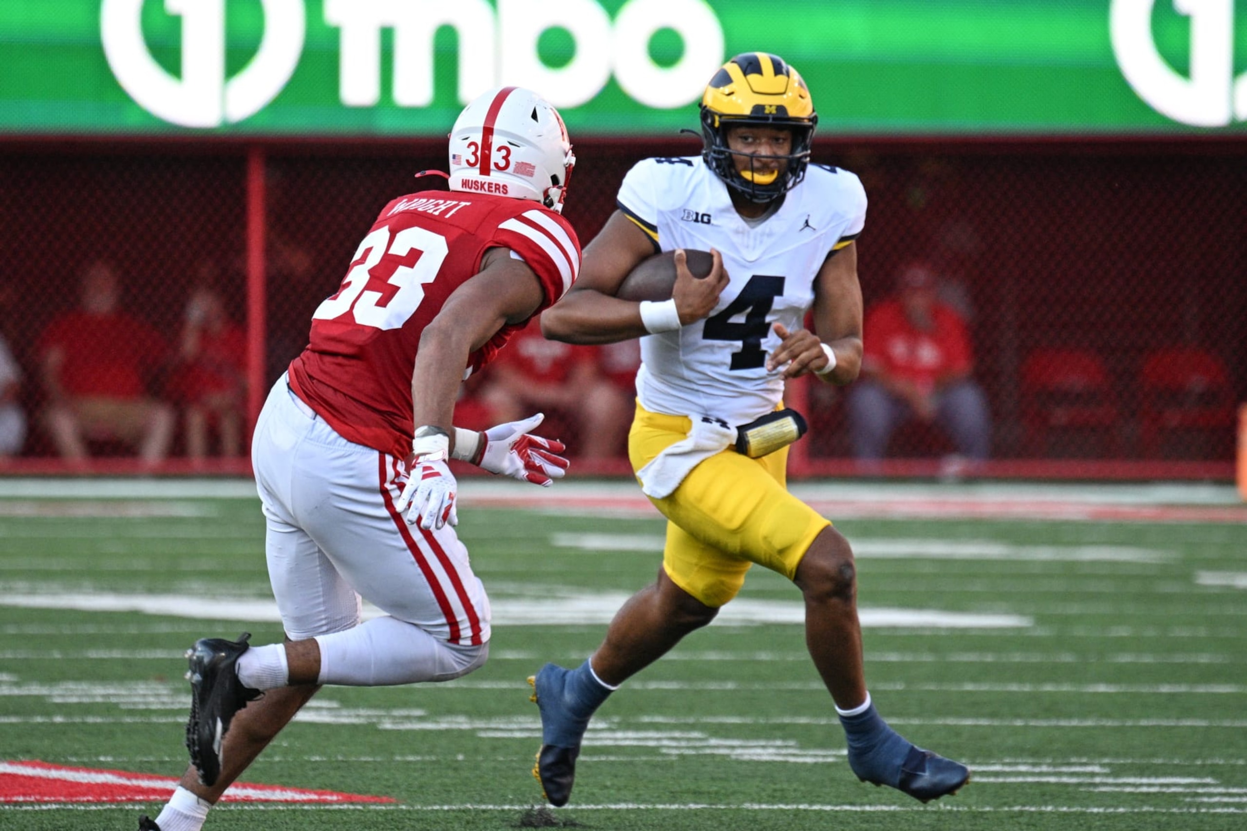 LINCOLN, NEBRASKA - SEPTEMBER 30: Quarterback Jayden Denegal #4 of the Michigan Wolverines runs from linebacker Javin Wright #33 of the Nebraska Cornhuskers in the second half at Memorial Stadium on September 30, 2023 in Lincoln, Nebraska. (Photo by Steven Branscombe/Getty Images)