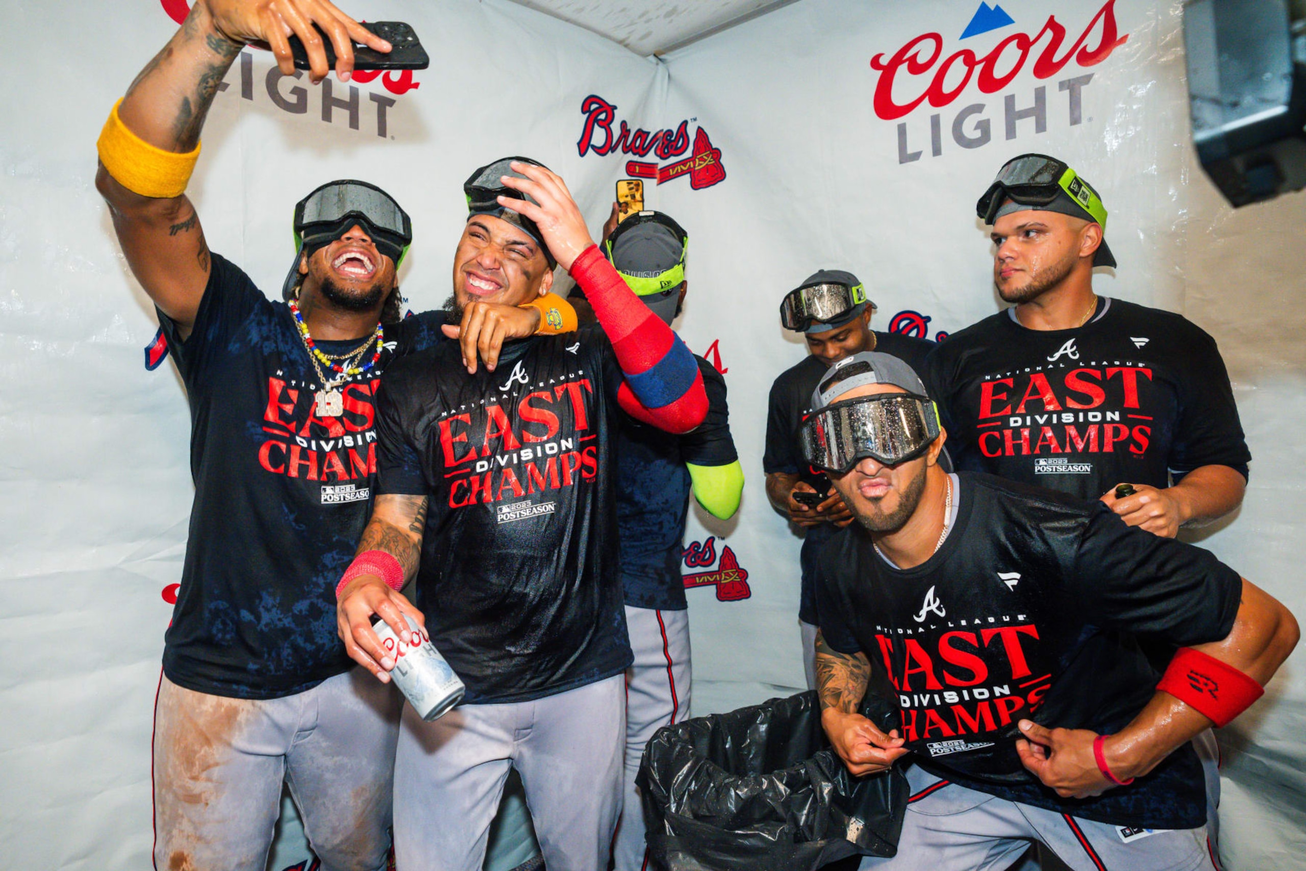 PHILADELPHIA, PA - SEPTEMBER 13: Ronald Acuna Jr. #13 of the Atlanta Braves (holding camera) and Orlando Arcia #11 celebrate with other teammates after defeating the Philadelphia Phillies to clinch the NL East at Citizens Bank Park on September 13, 2023 in Atlanta, Georgia. (Photo by Kevin D. Liles/Atlanta Braves/Getty Images) PHILADELPHIA, PA - SEPTEMBER 13: Ronald Acuna Jr. #13 of the Atlanta Braves (holding camera) and Orlando Arcia #11 celebrate with other teammates after defeating the Philadelphia Phillies to clinch the NL East at Citizens Bank Park on September 13, 2023 in Atlanta, Georgia. (Photo by Kevin D. Liles/Atlanta Braves/Getty Images)