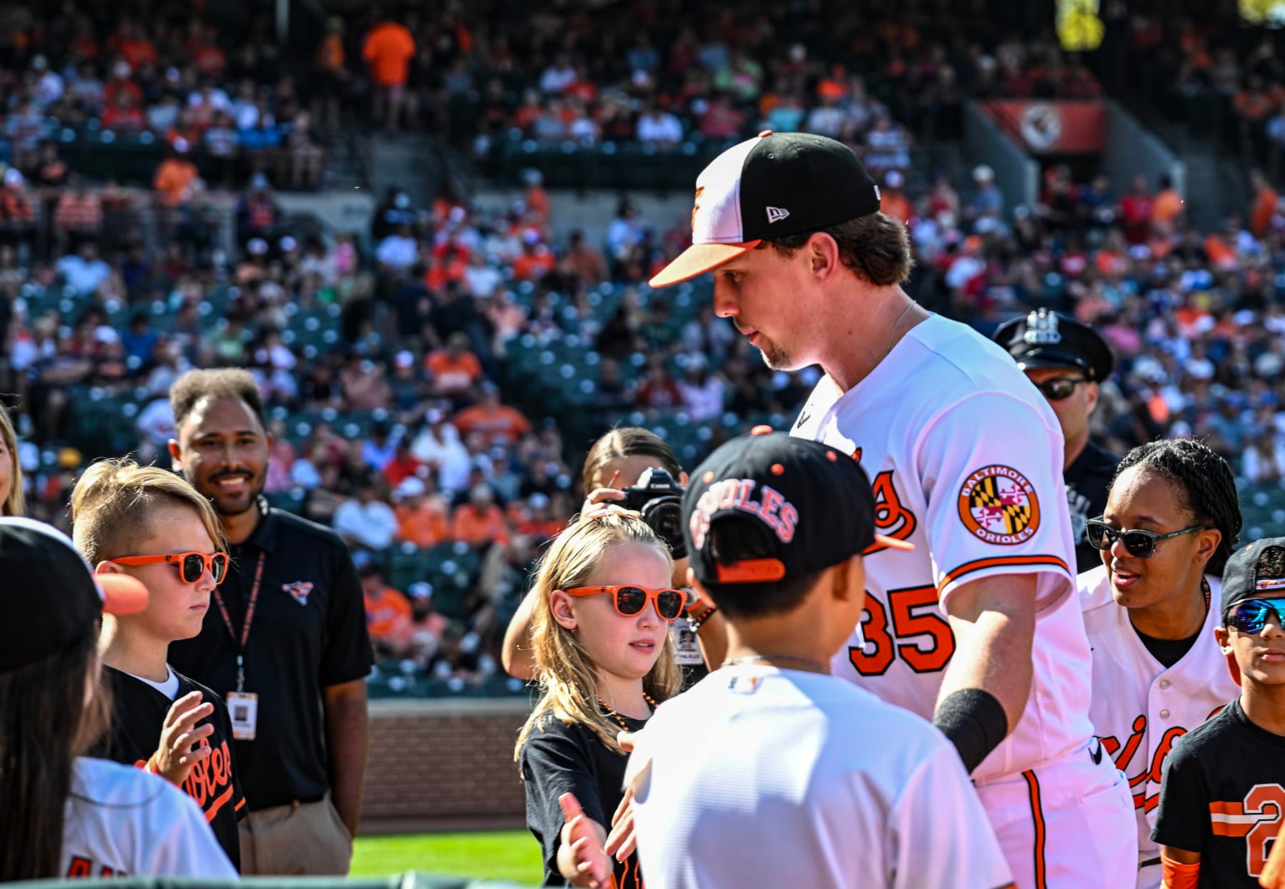 BALTIMORE, MD - October 01: Baltimore Orioles designated hitter Adley Rutschman (35) walks through a throng of children on the way to the dugout prior to the Boston Red Sox versus the Baltimore Orioles on October 1, 2023 at Oriole Park at Camden Yards in Baltimore, MD.  (Photo by Mark Goldman/Icon Sportswire via Getty Images)