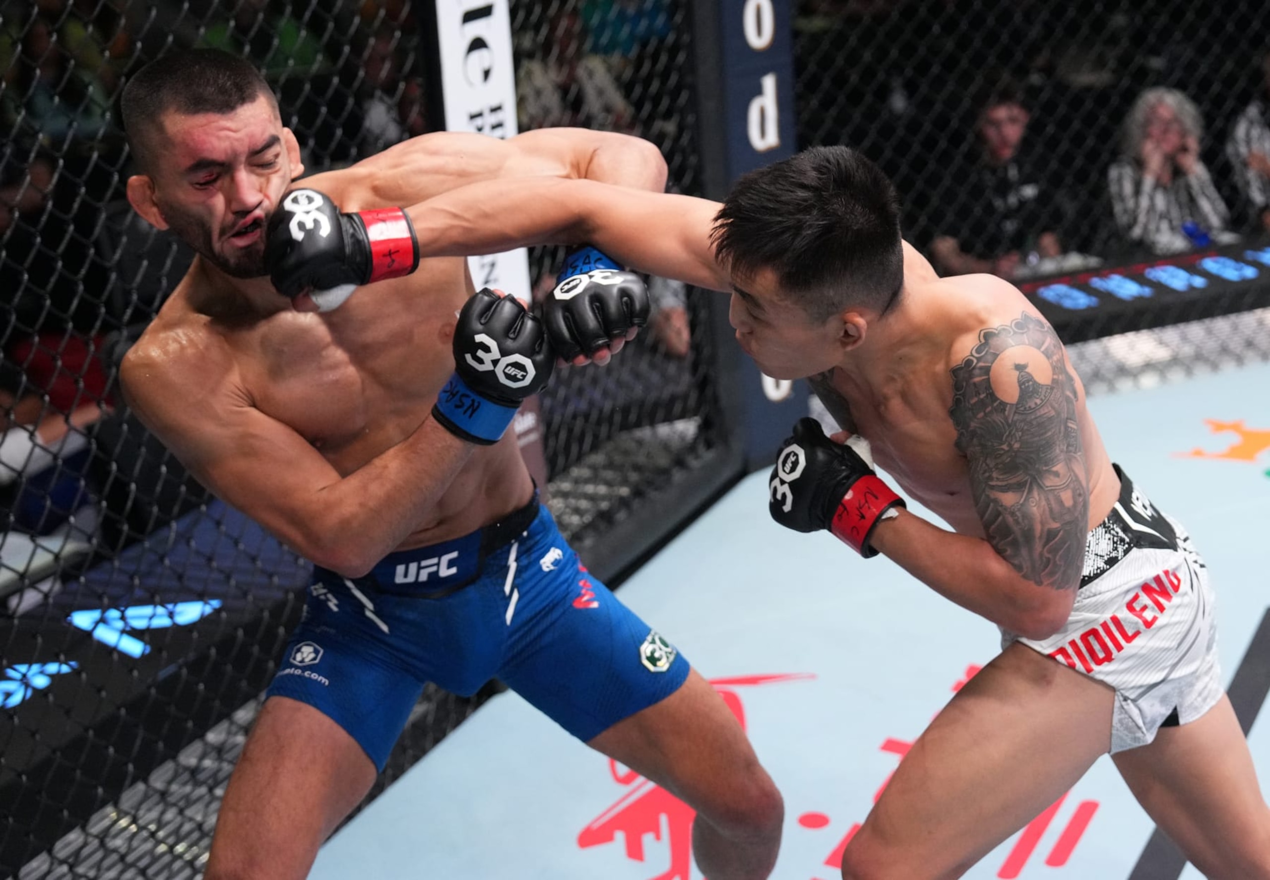 LAS VEGAS, NEVADA - OCTOBER 07: (R-L) Aoriqileng of China punches Johnny Munoz in a bantamweight fight during the UFC Fight Night weigh-in at UFC APEX on October 07, 2023 in Las Vegas, Nevada. (Photo by Al Powers/Zuffa LLC via Getty Images)