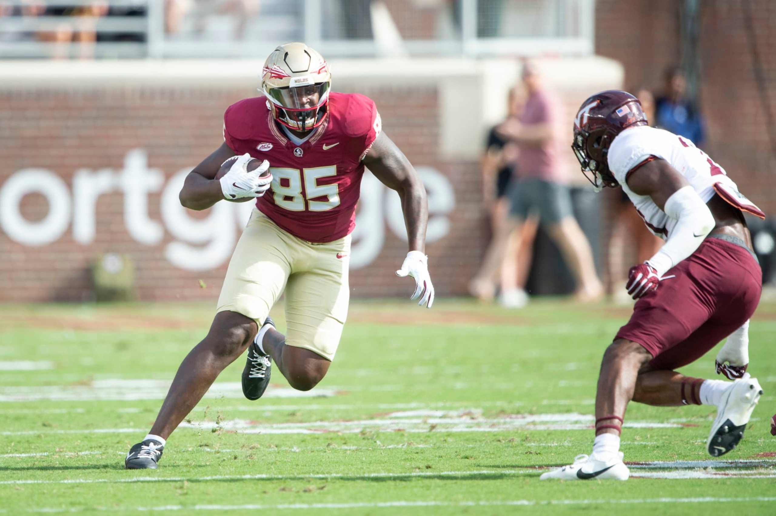 TALLAHASSEE, FLORIDA - OCTOBER 07: Tight end Markeston Douglas #85 of the Florida State Seminoles looks to maneuver the ball by linebacker Keli Lawson #21 of the Virginia Tech Hokies during the first half of play at Doak Campbell Stadium on October 07, 2023 in Tallahassee, Florida. (Photo by Michael Chang/Getty Images)