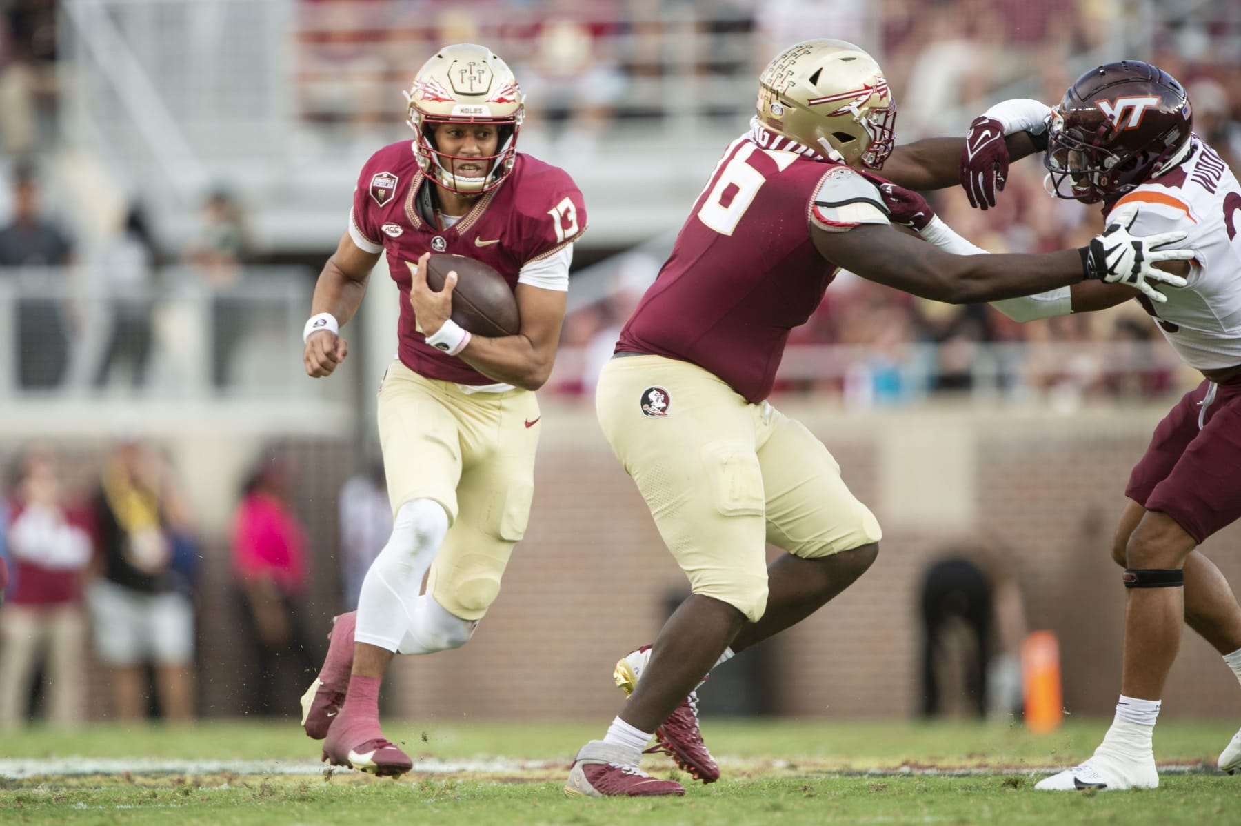 TALLAHASSEE, FLORIDA - OCTOBER 07: Quarterback Jordan Travis #13 of the Florida State Seminoles looks to runs the ball by safety Caleb Woodson #20 of the Virginia Tech Hokies during the second half of play at Doak Campbell Stadium on October 07, 2023 in Tallahassee, Florida. (Photo by Michael Chang/Getty Images)