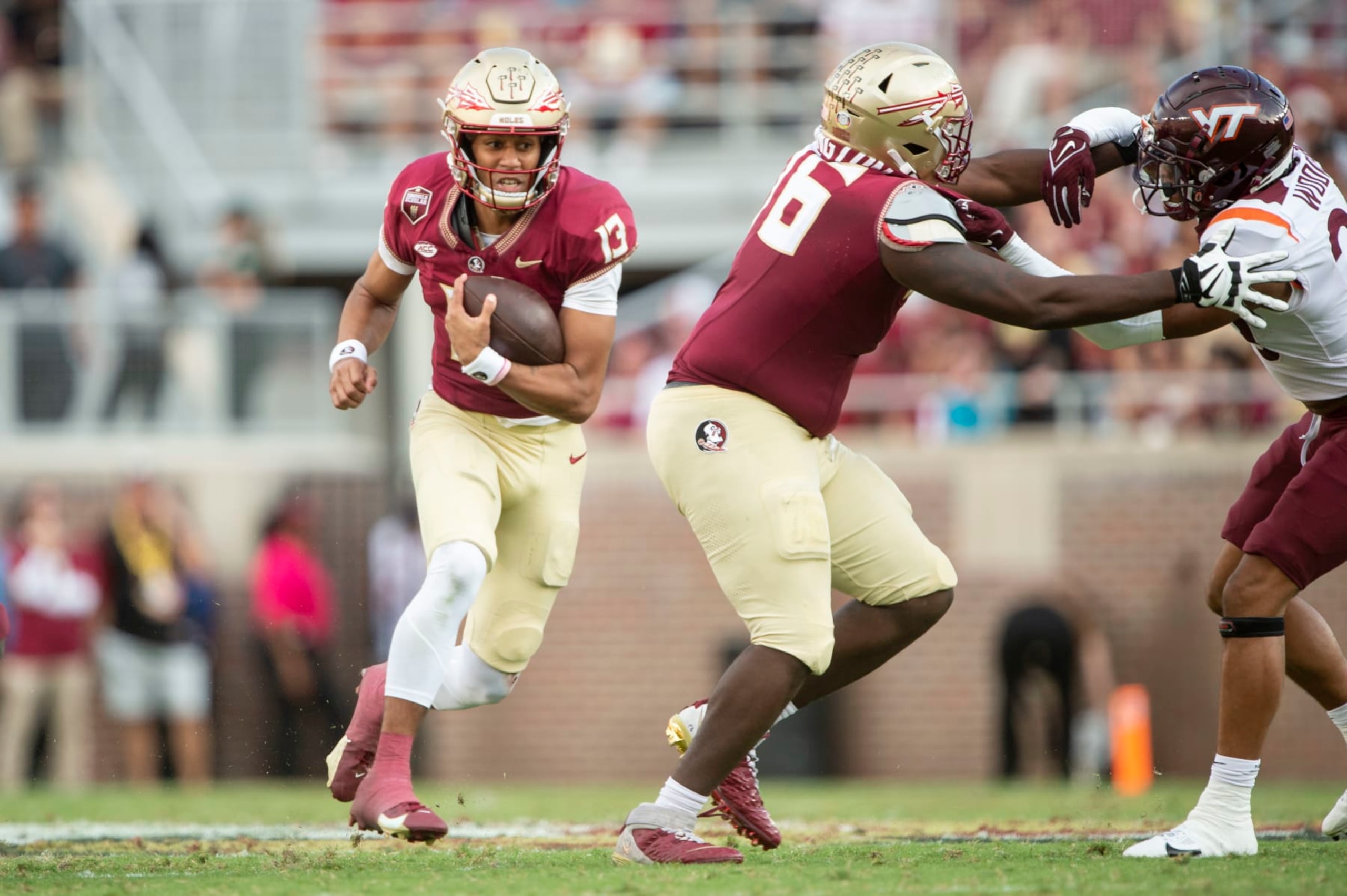 TALLAHASSEE, FLORIDA - OCTOBER 07: Quarterback Jordan Travis #13 of the Florida State Seminoles looks to runs the ball by safety Caleb Woodson #20 of the Virginia Tech Hokies during the second half of play at Doak Campbell Stadium on October 07, 2023 in Tallahassee, Florida. (Photo by Michael Chang/Getty Images)