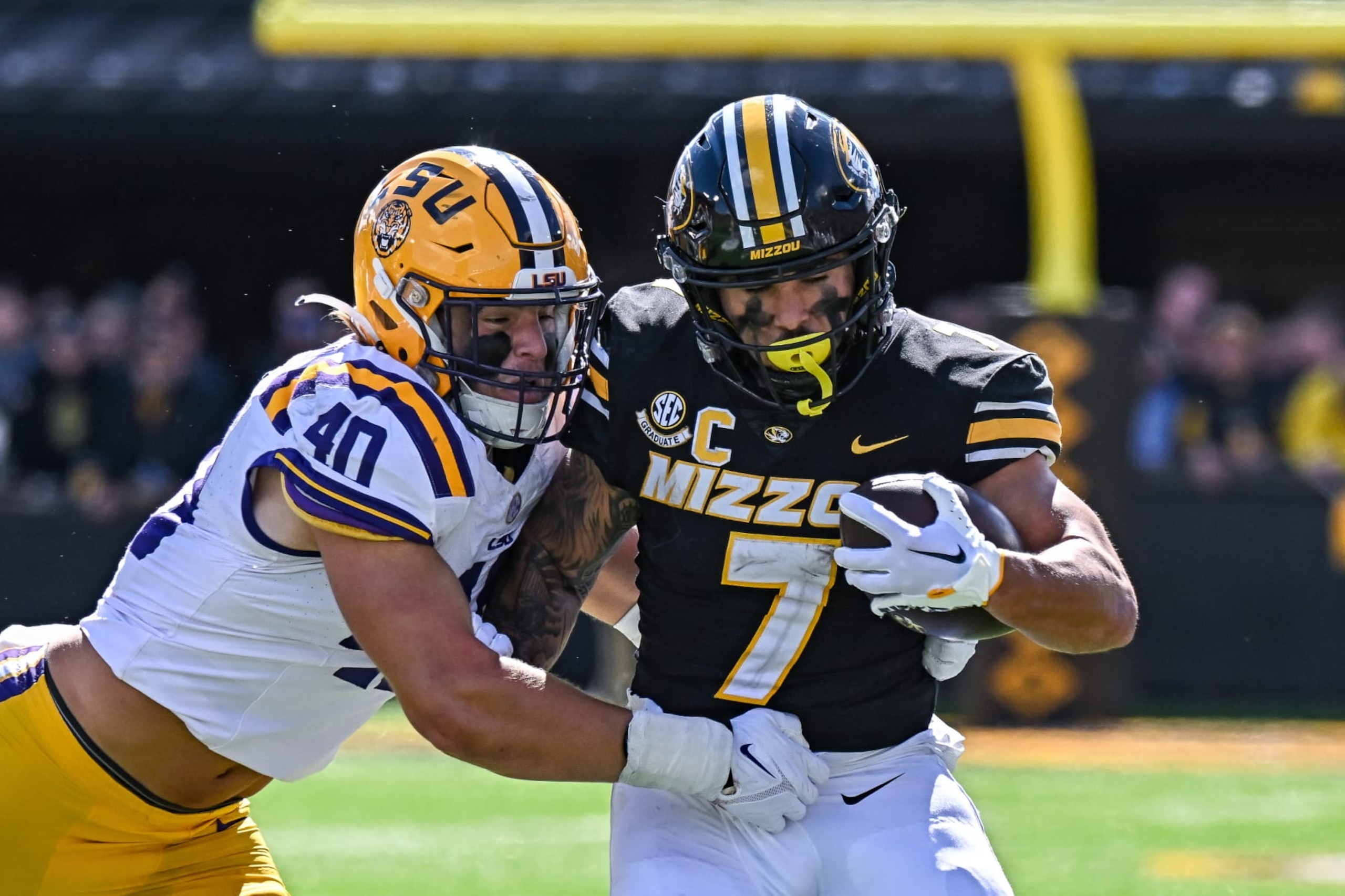 COLUMBIA, MO - OCTOBER 07: Missouri Tigers running back Cody Schrader (7) works to get away from the tackle attempt fo LSU Tigers linebacker Whit Weeks (40) during a SEC conference game between the Louisiana State  Tigers and the Missouri Tigers held on Saturday Oct 07, 2023 at Faurot Field at Memorial Stadium in Columbia MO. (Photo by Rick Ulreich/Icon Sportswire via Getty Images