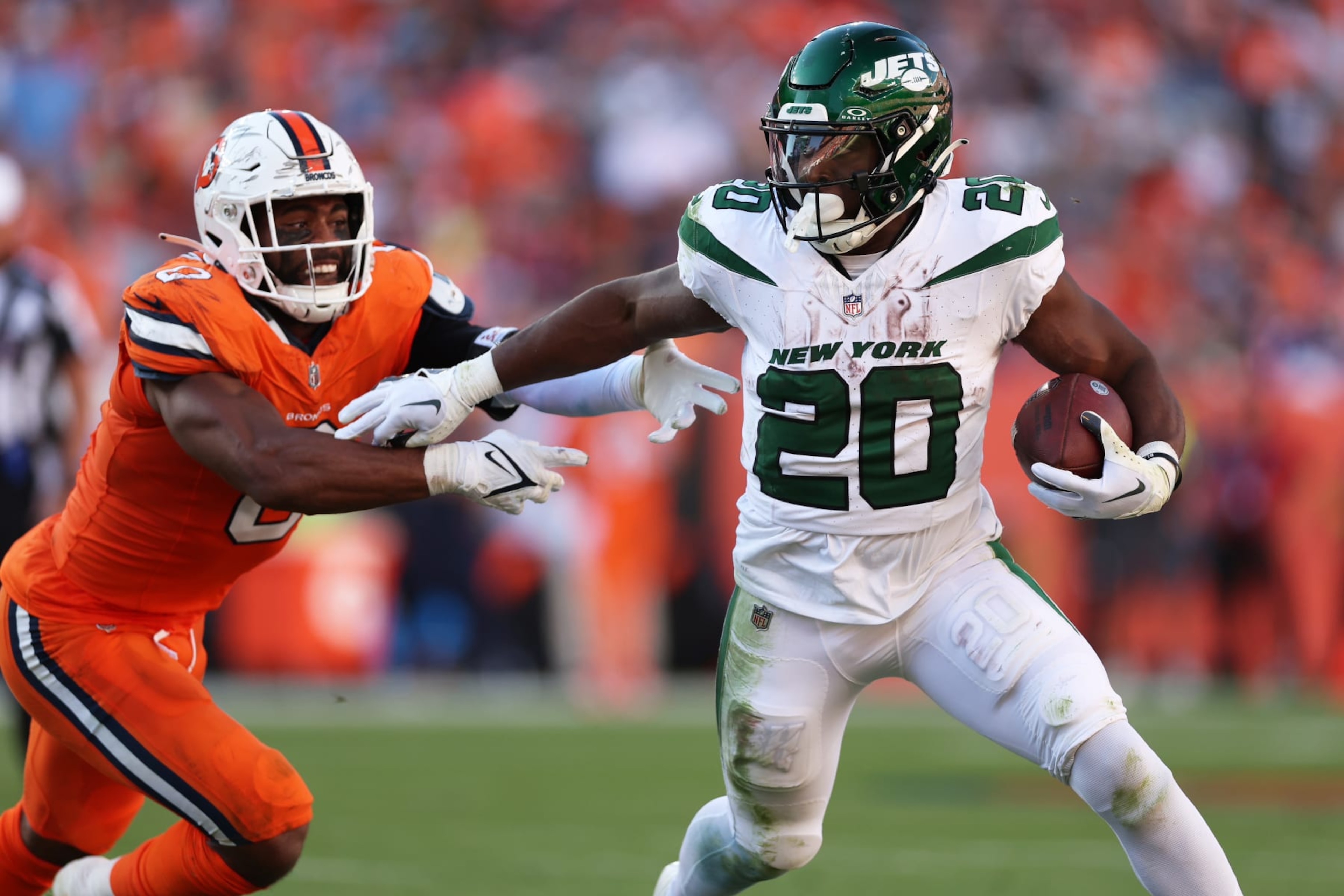 DENVER, COLORADO - OCTOBER 08: Breece Hall #20 of the New York Jets runs with the ball while being chased by Jonathon Cooper #0 of the Denver Broncos in the fourth quarter at Empower Field At Mile High on October 08, 2023 in Denver, Colorado. (Photo by Matthew Stockman/Getty Images)