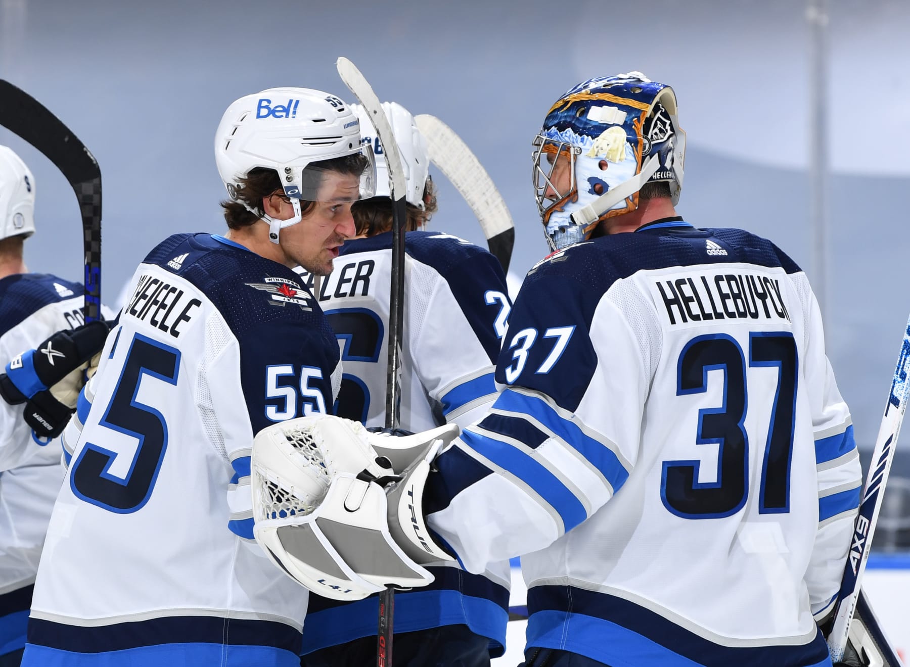 EDMONTON, AB - MAY 19:  Mark Scheifele #55 and Connor Hellebuyck #37 of the Winnipeg Jets celebrate after winning Game One of the First Round of the 2021 Stanley Cup Playoffs against the Edmonton Oilers on May 19, 2021 at Rogers Place in Edmonton, Alberta, Canada. (Photo by Andy Devlin/NHLI via Getty Images)
