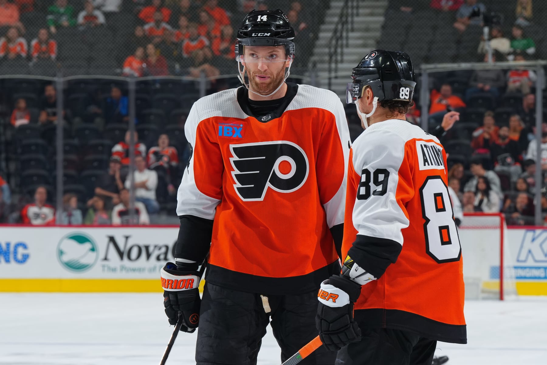 PHILADELPHIA, PENNSYLVANIA - OCTOBER 5: Sean Couturier #14 of the Philadelphia Flyers talks to Cam Atkinson #89 in the preseason game against the New York Islanders at the Wells Fargo Center on October 5, 2023 in Philadelphia, Pennsylvania. The Flyers defeated the Islanders 5-2. (Photo by Mitchell Leff/Getty Images)