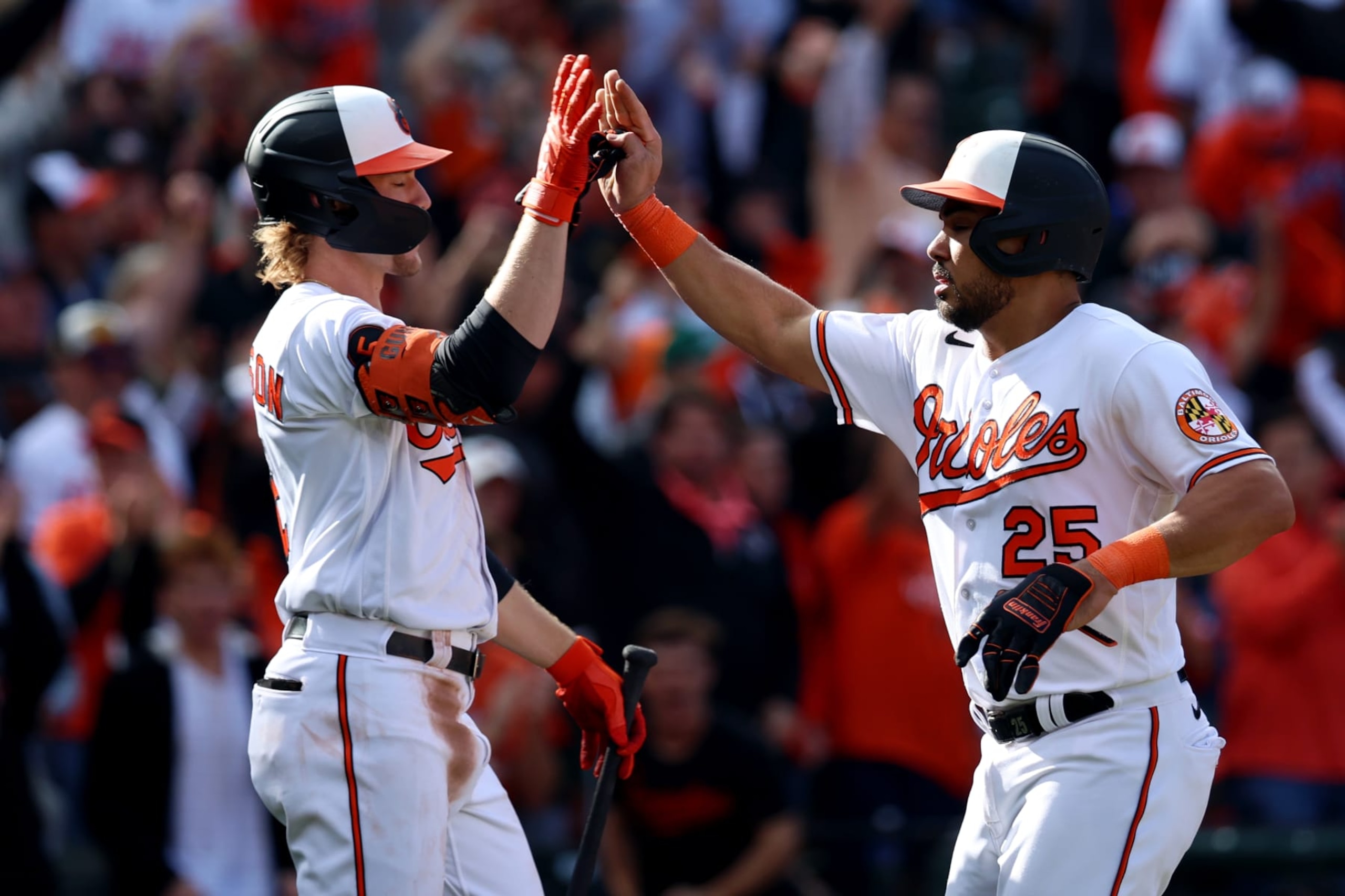 BALTIMORE, MD - OCTOBER 07:  Anthony Santander #25 of the Baltimore Orioles celebrates with teammate Gunnar Henderson #2 after scoring a run in the fourth inning during Game 1 of the Division Series between the Texas Rangers and the Baltimore Orioles at Oriole Park at Camden Yards on Saturday, October 7, 2023 in Baltimore, Maryland. (Photo by Rob Tringali/MLB Photos via Getty Images)