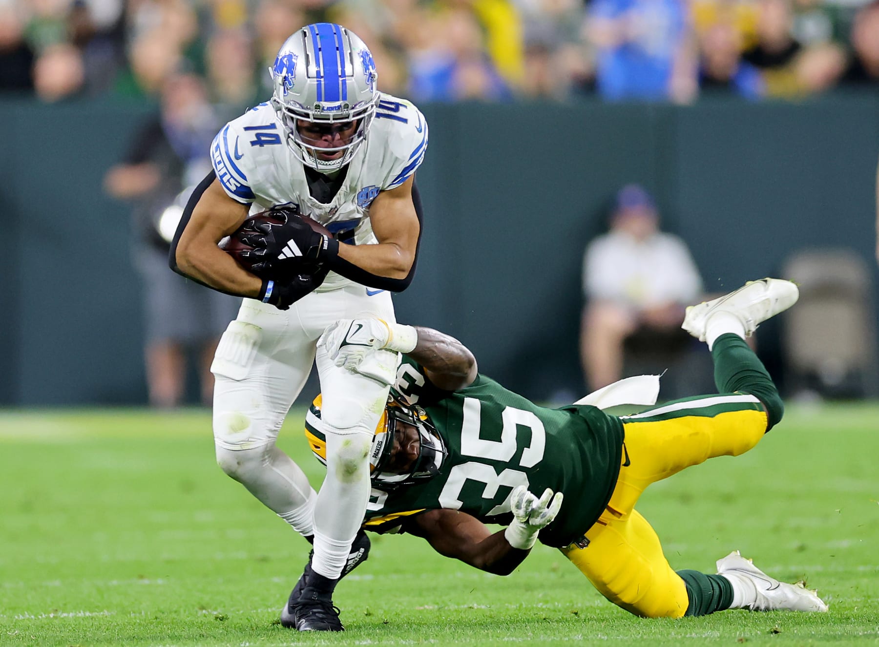 GREEN BAY, WISCONSIN - SEPTEMBER 28: Corey Ballentine #35 of the Green Bay Packers tackles Amon-Ra St. Brown #14 of the Detroit Lions during the second quarter in the game at Lambeau Field on September 28, 2023 in Green Bay, Wisconsin. (Photo by Stacy Revere/Getty Images)