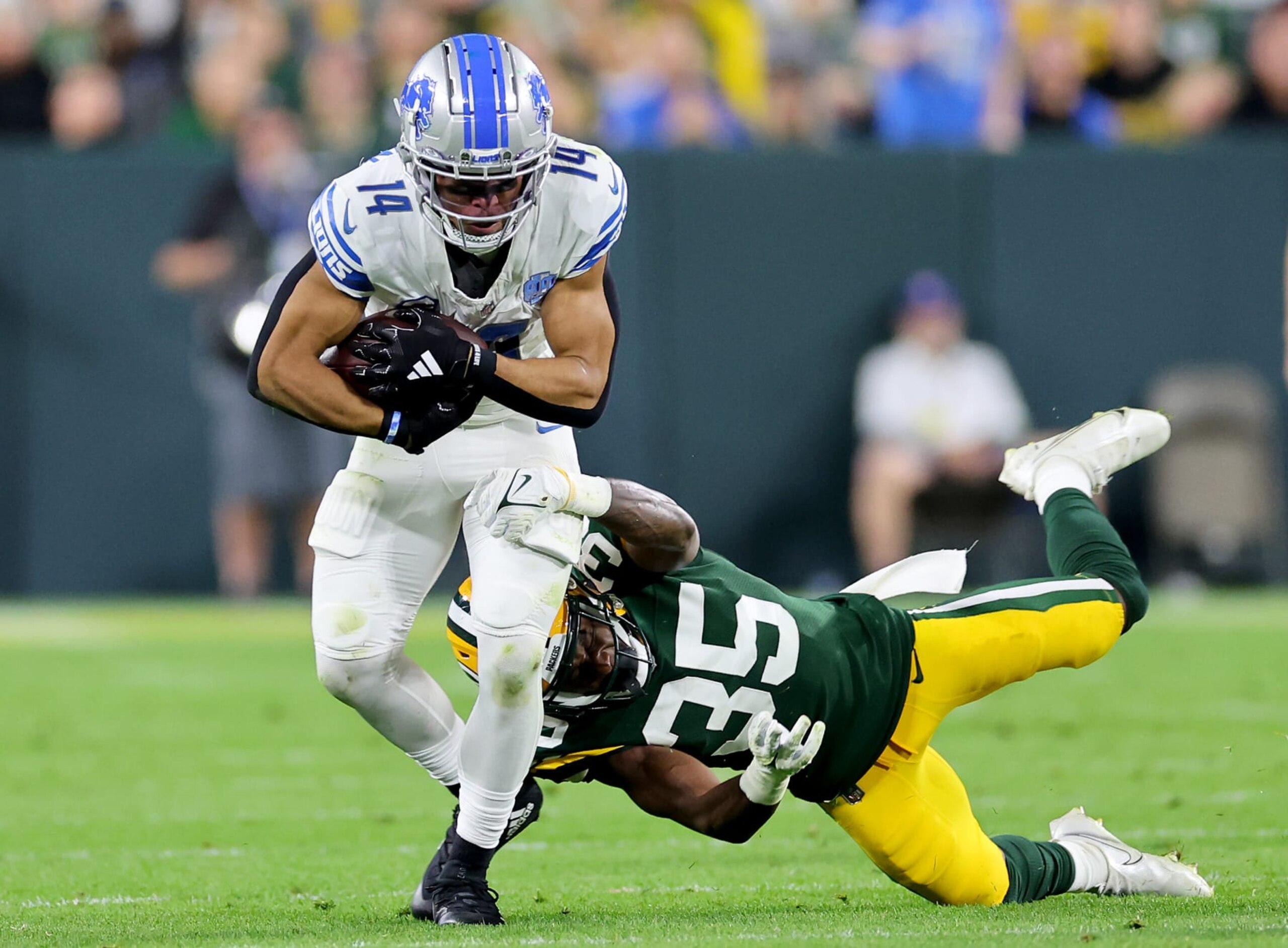 GREEN BAY, WISCONSIN - SEPTEMBER 28: Corey Ballentine #35 of the Green Bay Packers tackles Amon-Ra St. Brown #14 of the Detroit Lions during the second quarter in the game at Lambeau Field on September 28, 2023 in Green Bay, Wisconsin. (Photo by Stacy Revere/Getty Images)