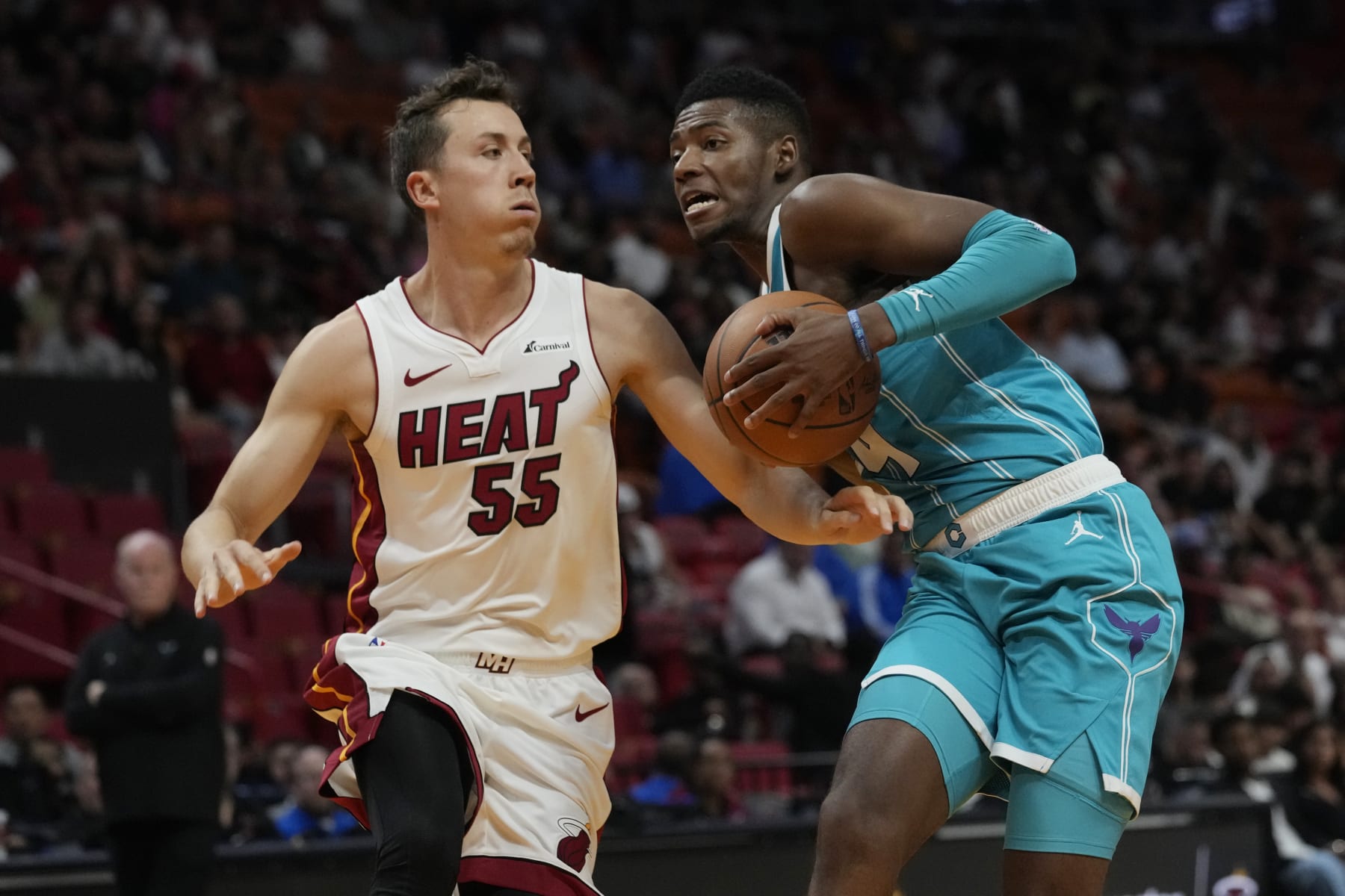 Miami Heat forward Duncan Robinson (55) defends Charlotte Hornets forward Brandon Miller during the first half of an NBA preseason basketball game, Tuesday, Oct. 10, 2023, in Miami. (AP Photo/Marta Lavandier)
