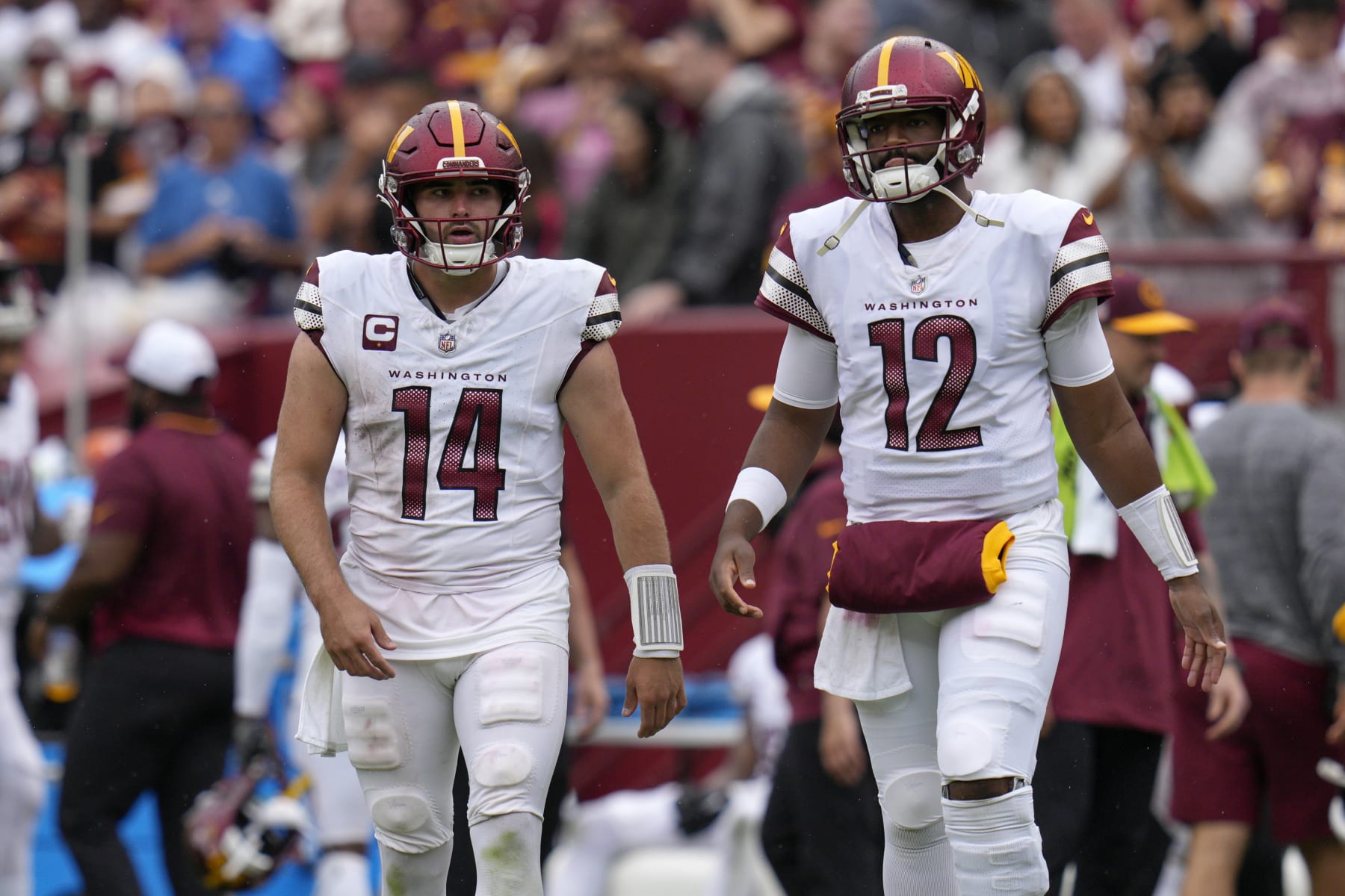 LANDOVER, MARYLAND - SEPTEMBER 10: Sam Howell #14 of the Washington Commanders and Jacoby Brissett #12 walk on the field tocelebrate with teammates after a successful extra point kick during the fourth quarter against the Arizona Cardinals at FedExField on September 10, 2023 in Landover, Maryland. (Photo by Jess Rapfogel/Getty Images)
