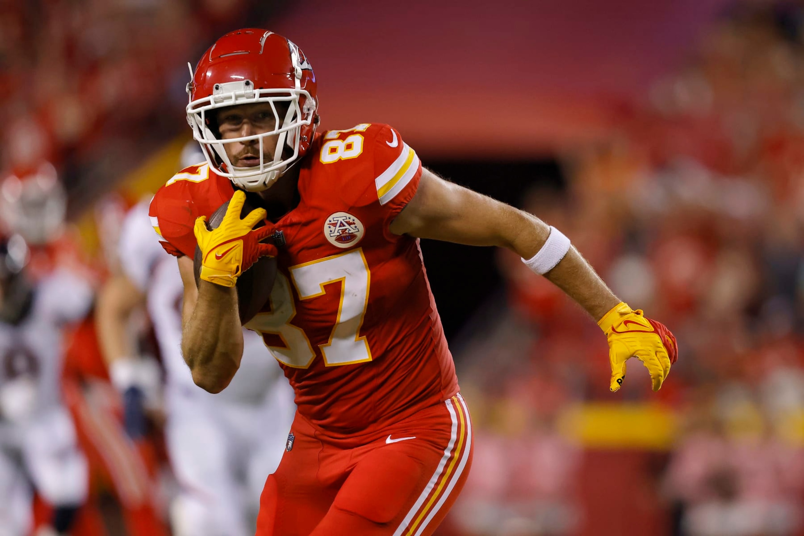 KANSAS CITY, MISSOURI - OCTOBER 12: Travis Kelce #87 of the Kansas City Chiefs carries the ball against the Denver Broncos during the second quarter at GEHA Field at Arrowhead Stadium on October 12, 2023 in Kansas City, Missouri. (Photo by David Eulitt/Getty Images)