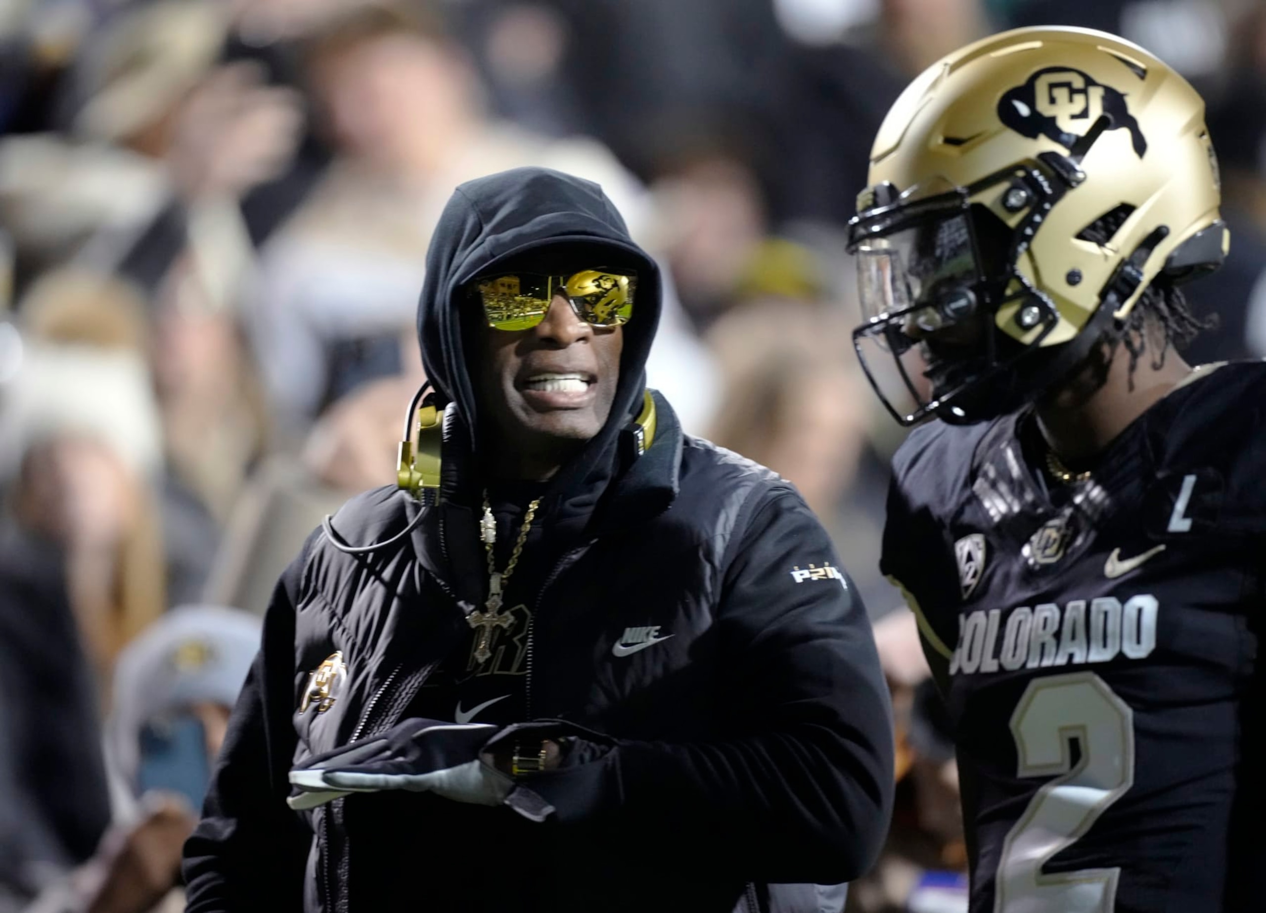 Colorado coach Deion Sanders, left, talks to quarterback Shedeur Sanders, his son, during the first half of the team's NCAA college football game against Stanford on Friday, Oct. 13, 2023, in Boulder, Colo. (AP Photo/David Zalubowski) Colorado coach Deion Sanders, left, talks to quarterback Shedeur Sanders, his son, during the first half of the team's NCAA college football game against Stanford on Friday, Oct. 13, 2023, in Boulder, Colo. (AP Photo/David Zalubowski)